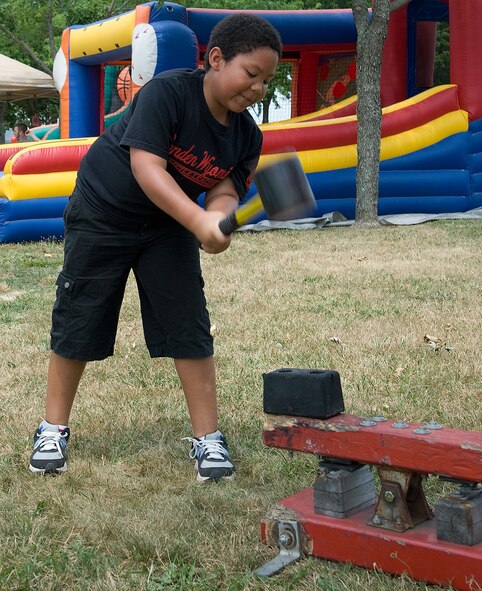 Richie Sironen tests his strength in the strongman game at the Wing Picnic July 3, 2012, at Dover Air Force Base, Del. The strongman game was one of many games children could enjoy at the base-wide event. (U.S. Air Force photo by Adrian Rowan)