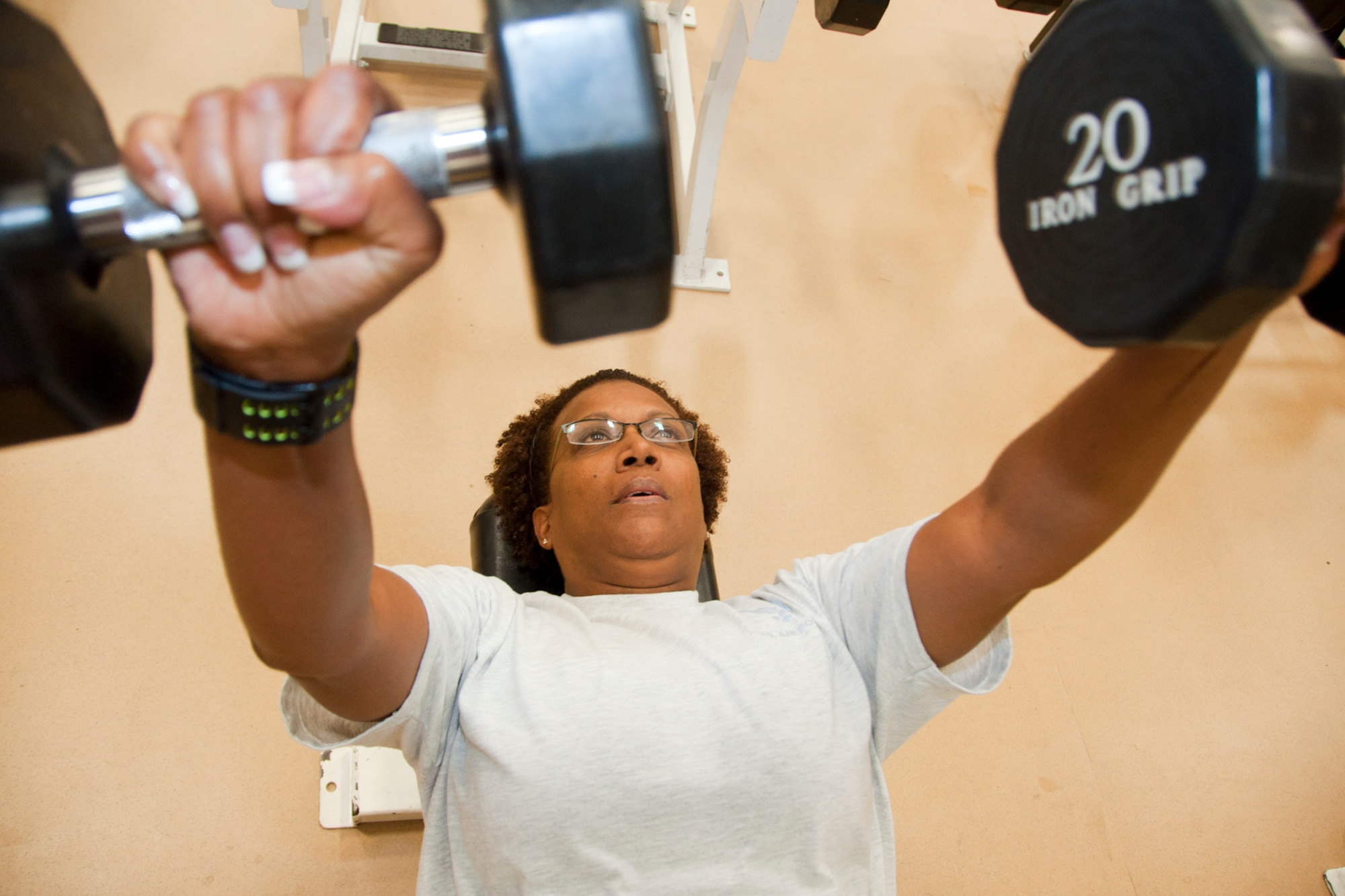 ROBINS AIR FORCE BASE, Ga. - Master Sgt. Michele Smith, unit training manager for the Readiness  Management Group here, conducts strength-training with weights in an effort to maintain a healthy lifestyle. Smith was diagnosed with two cerebral aneurysms last year after failing her fitness test. After surgery, Smith changed her fitness regimen and passed her PT test. (U.S. Air Force photo/Staff Sgt. Megan Tomkins)
