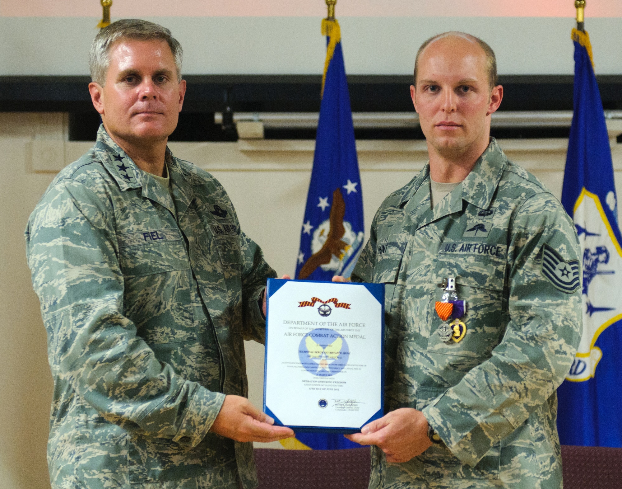 Lt. Gen. Eric Fiel, commander of the U.S. Air Force Special Operations Command, presents an Air Force Combat Action Medal to Tech. Sgt. Bryan Hunt, 123rd Special Tactics Squadron combat controller, at the Kentucky Air National Guard Base in Louisville, Ky., on June 28, 2012. Hunt was also awarded a Purple Heart for being wounded in action while serving overseas. (U.S. Air Force photo by Master Sgt. Phil Speck)