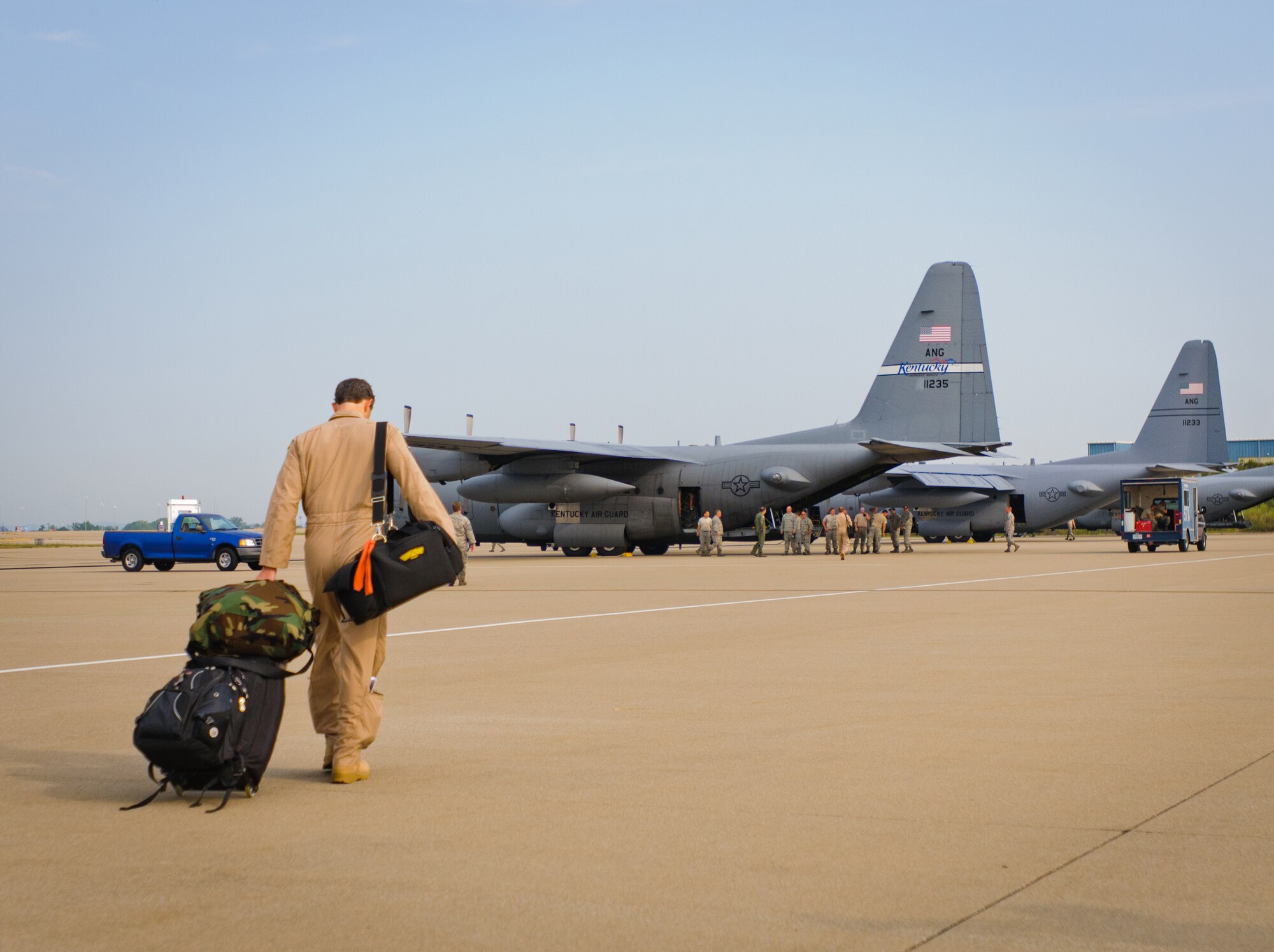 A member of the 123rd Airlift Wing walks to a Kentucky Air Guard C-130 aircraft prior to takeoff for a deployment at the Kentucky Air National Guard Base in Louisville, Ky., on July 2, 2012. The 123rd Airlift Wing deployed 70 Airmen and two C-130 aircraft to the Persian Gulf region in support of operations Enduring Freedom and New Dawn. (U.S. Air Force photo by Master Sgt. Phil Speck)