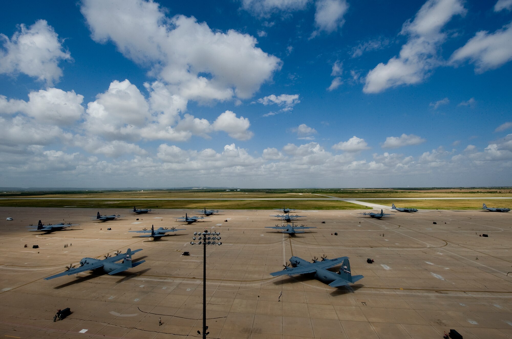 C-130Js taxi toward the runway during a training exercise July, 2, 2012, at Dyess Air Force Base, Texas.  The simulated mission was an airdrop above two different drop zones. Once the final aircraft was airborne, the 317th Airlift Group made history, flying the largest C-130J formation ever. The first C-130J was delivered April 16, 2010, by Air Force Chief of Staff Gen. Norton Schwartz. Dyess has since received 20 more and is scheduled to get a total of 28 Js, making it the largest C-130J unit in the world. (U.S. Air Force photo by Airman 1st Class Damon Kasberg/Released)