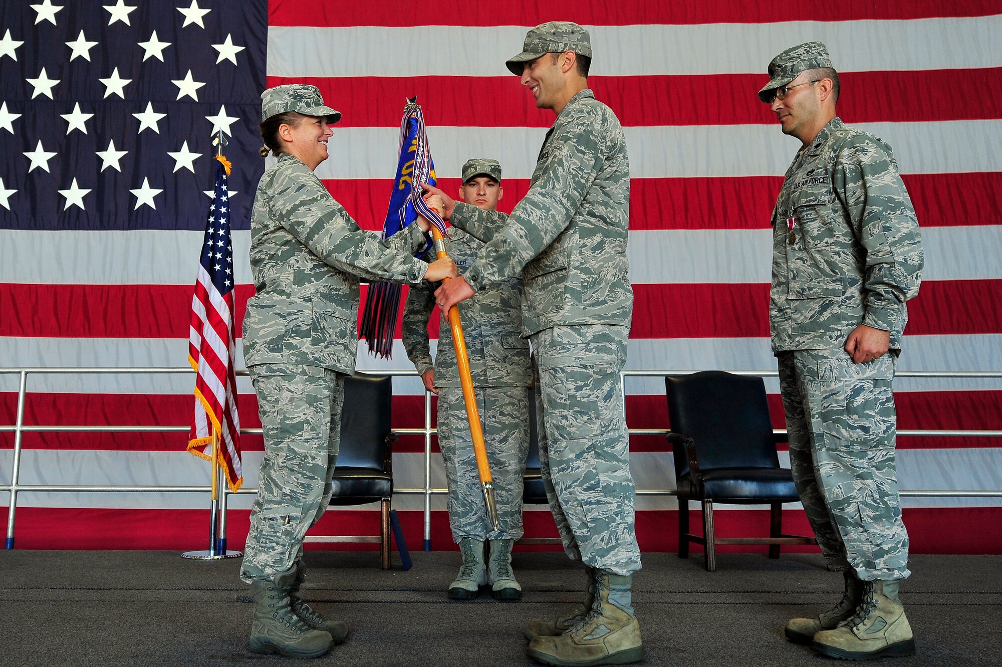 U.S. Air Force Col. Helen Brasher, 20th Maintenance Group commander hands the 20th Equipment Maintenance Squadron guidon to Maj. Joshua Wennrich, as he takes command of the 20th EMS during a change of command ceremony, June 29, 2012, Shaw Air Force Base, S.C. Lt. Col. James Smith relinquished command to Wennrich. Wennrich arrived at Shaw from Royal Air Force Lakenheath Air Base, England. (U.S. Air Force photo by Senior Airman Kenny Holston/Released) 