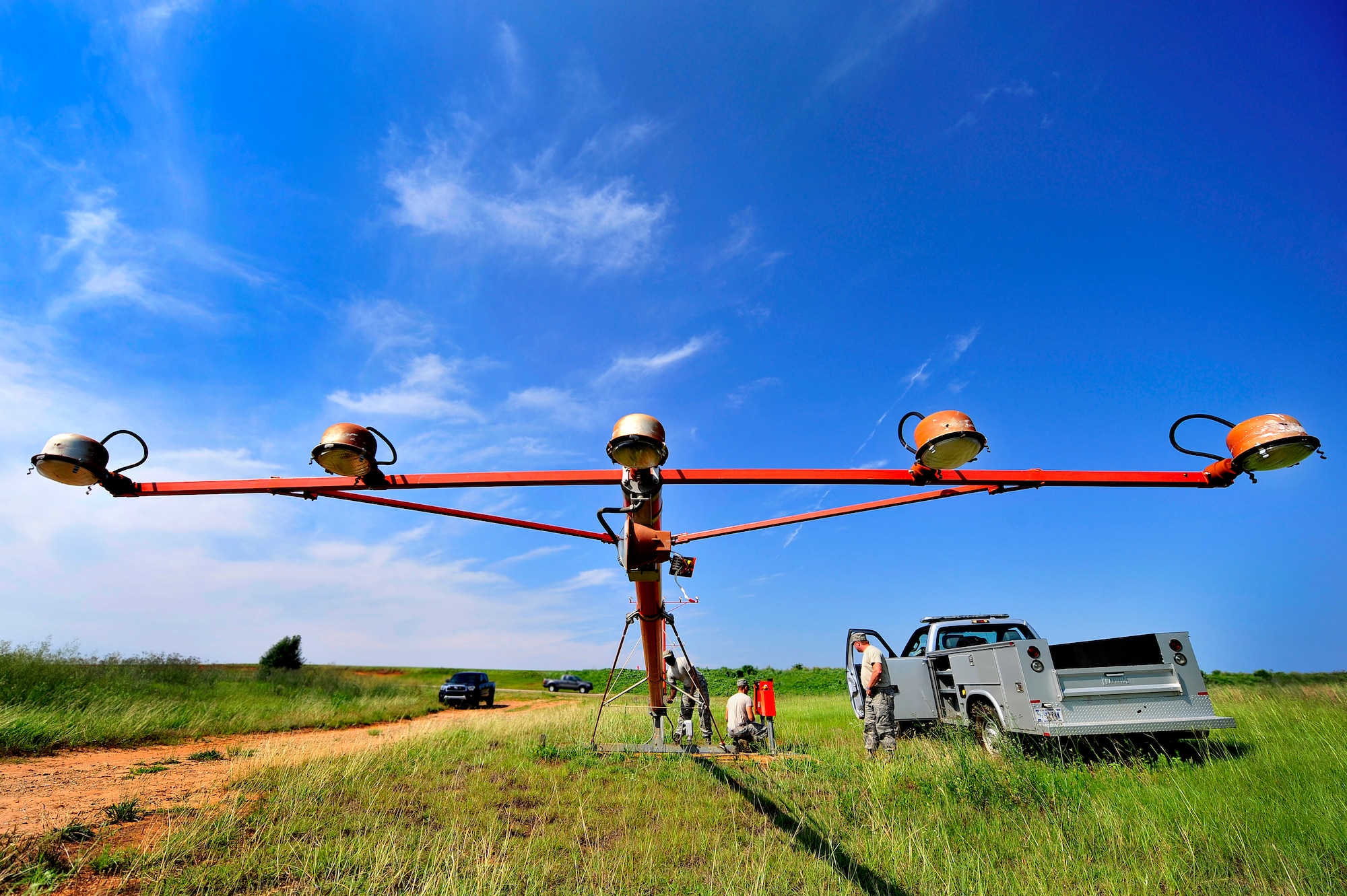 (From left), U.S. Air Force Staff Sgt. Julius Givens, Airman 1st Class Justin Fleming, and Tech. Sgt. Daniel Harrington, all 20th Civil Engineer Squadron, repair airfield approach lighting at Shaw Air Force Base, S.C., June 26, 2012. The 20th CES Airmen worked together to repair several airfield lighting lamps and re-sync flashing approach lights. Shaw’s airfield lighting system is vital to all pilots who land and take off from the flightline. (U.S. Air Force photo by Senior Airman Kenny Holston/Released)
