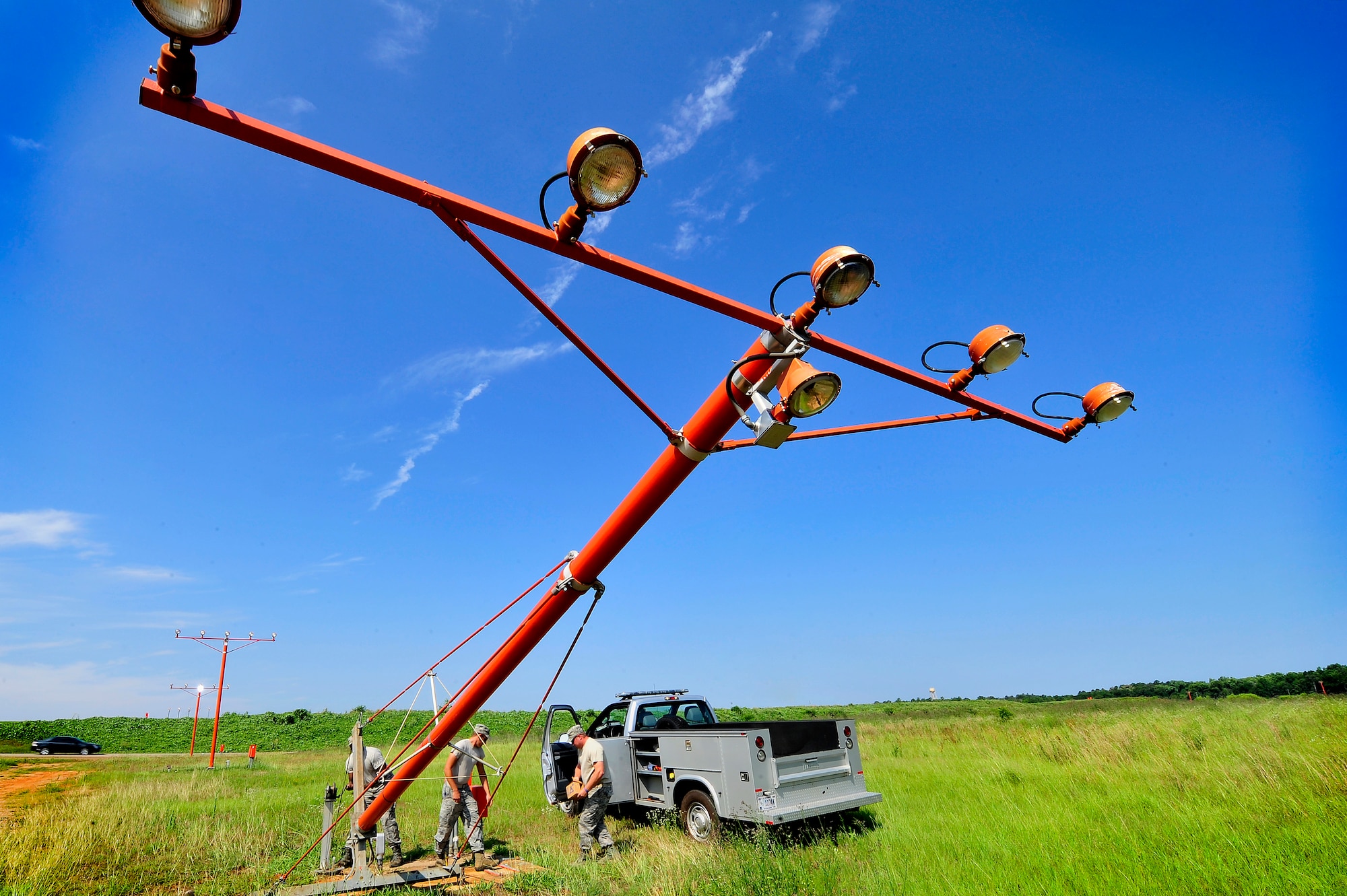 (From left), U.S. Air Force Staff Sgt. Julius Givens, Airman 1st Class Justin Fleming, and Tech. Sgt. Daniel Harrington, all 20th Civil Engineer Squadron, repair airfield approach lighting, Shaw Air Force Base, S.C., June 26, 2012. The 20th CES Airmen worked together to repair several airfield lighting lamps and re-sync flashing approach lights. Shaw’s airfield lighting system is vital to all pilots who land and take off from the flightline. (U.S. Air Force photo by Senior Airman Kenny Holston/Released)