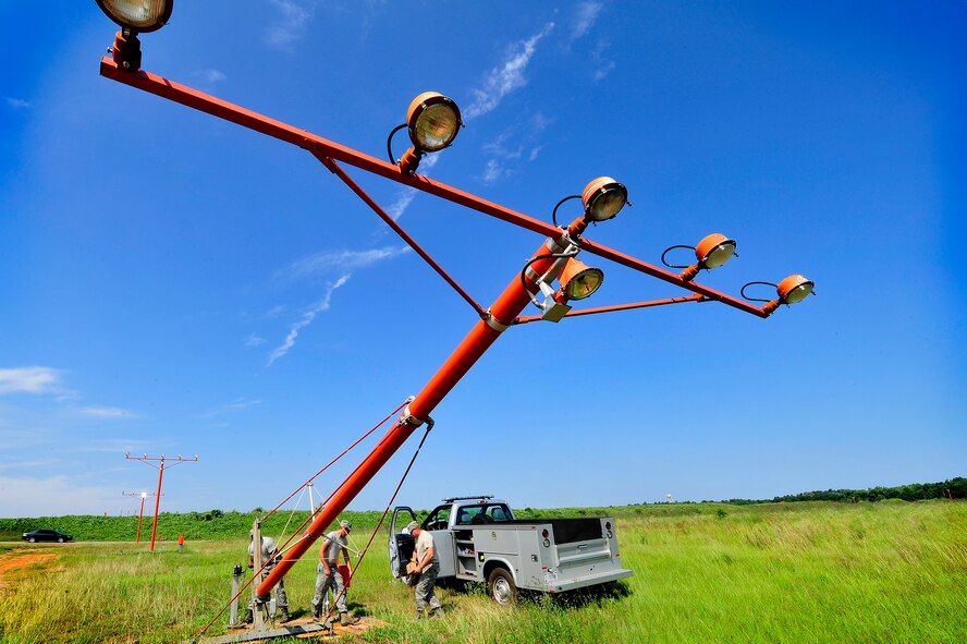 (From left), U.S. Air Force Staff Sgt. Julius Givens, Airman 1st Class Justin Fleming, and Tech. Sgt. Daniel Harrington, all 20th Civil Engineer Squadron, repair airfield approach lighting, Shaw Air Force Base, S.C., June 26, 2012. The 20th CES Airmen worked together to repair several airfield lighting lamps and re-sync flashing approach lights. Shaw’s airfield lighting system is vital to all pilots who land and take off from the flightline. (U.S. Air Force photo by Senior Airman Kenny Holston/Released)