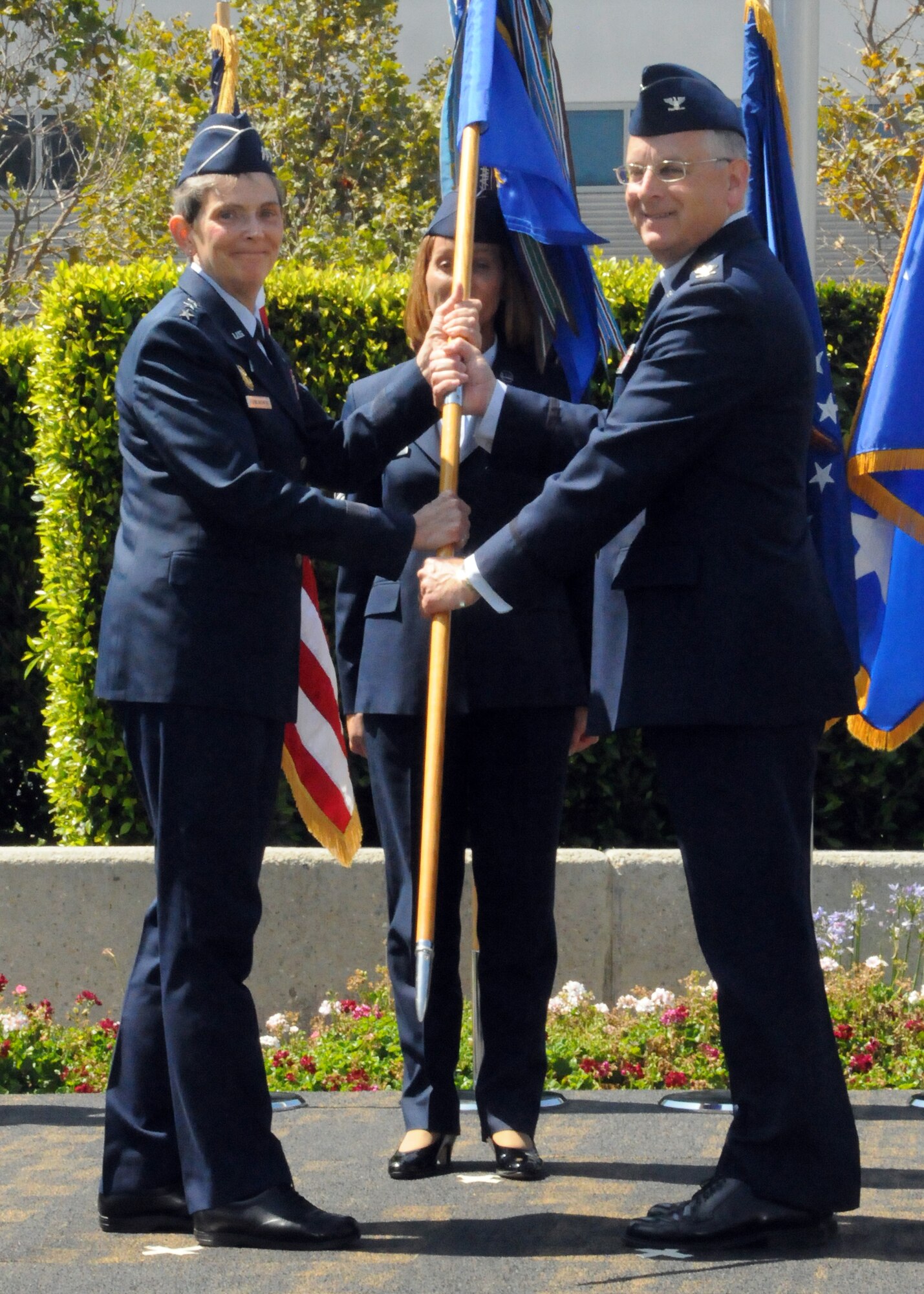 Colonel Samuel McNiel, new 61st ABG commander, receives the group’s flag from Lt. Gen. Ellen Pawlikowski during the 61st Air Base Group’s change of command ceremony, June 29. (Photo by Jim Gordon)