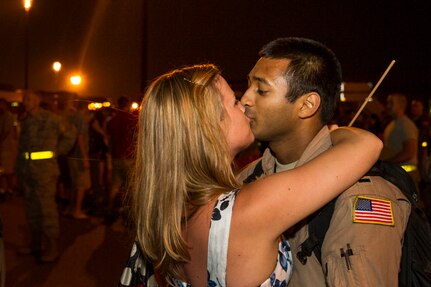 1st Lt. Imran Khan, 16th Airlift Squadron, 437th Airlift Wing pilot, kisses his wife Grace after returning from a deployment at Joint Base Charleston - Air Base, S.C., July 2, 2012. While deployed, the 16th AS served under the 816th Expeditionary Airlift Squadron, supporting combat operations in the U.S. Central Command area of responsibility. (U.S. Air Force photo by Airman 1st Class George Goslin/Released)