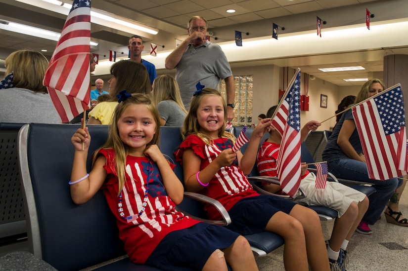 Kinsley and Karley Bordeaux, daughters of Master Sgt. Harold Bordeaux Jr., 16th Airlift Squadron, 437th Airlift Wing loadmaster, wait for their father to return from deployment at Joint Base Charleston - Air Base, S.C., July 2, 2012. While deployed, the 16th AS served under the 816th Expeditionary Airlift Squadron, supporting combat operations in the U.S. Central Command area of responsibility. (U.S. Air Force photo by Airman 1st Class George Goslin/Released)