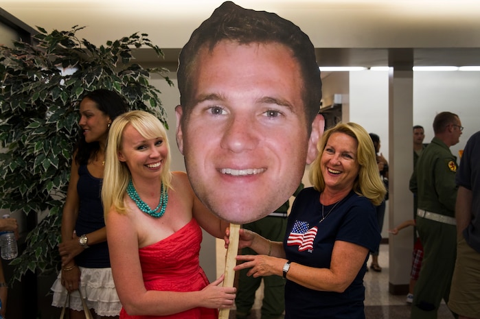 Ashley Smith, wife of Capt. Ben Smith, 16th Airlift Squadron, 437th Airlift Wing pilot, poses for a portrait holding an enlarged photo of her husband with Smith’s mother Anne, before the redeployment of the 16th AS at Joint Base Charleston - Air Base, S.C., July 2, 2012. While deployed, the 16th AS served under the 816th Expeditionary Airlift Squadron, supporting combat operations in the U.S. Central Command area of responsibility. (U.S. Air Force photo by Airman 1st Class George Goslin/Released)