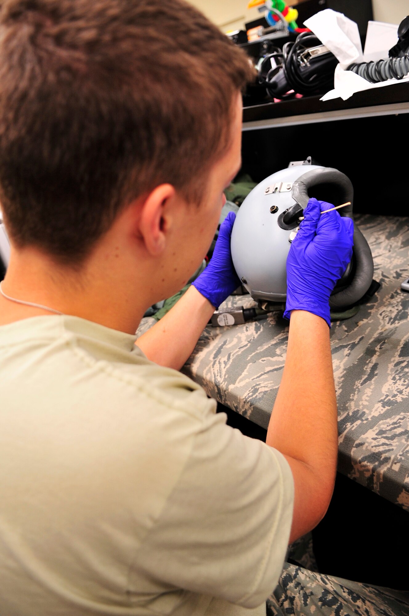 U.S. Air Force Airman Jesse Seeber, 79th Fighter Squadron aircrew flight equipment journeyman, removes soap scum from a helmet at Shaw Air Force Base, S.C., July 2, 2012.  Aircrew flight equipment personnel are responsible for ensuring the safety of the fighter pilots and integrity of their equipment.(U.S. Air Force photo by Airman Nicole Sikorski/Released) 