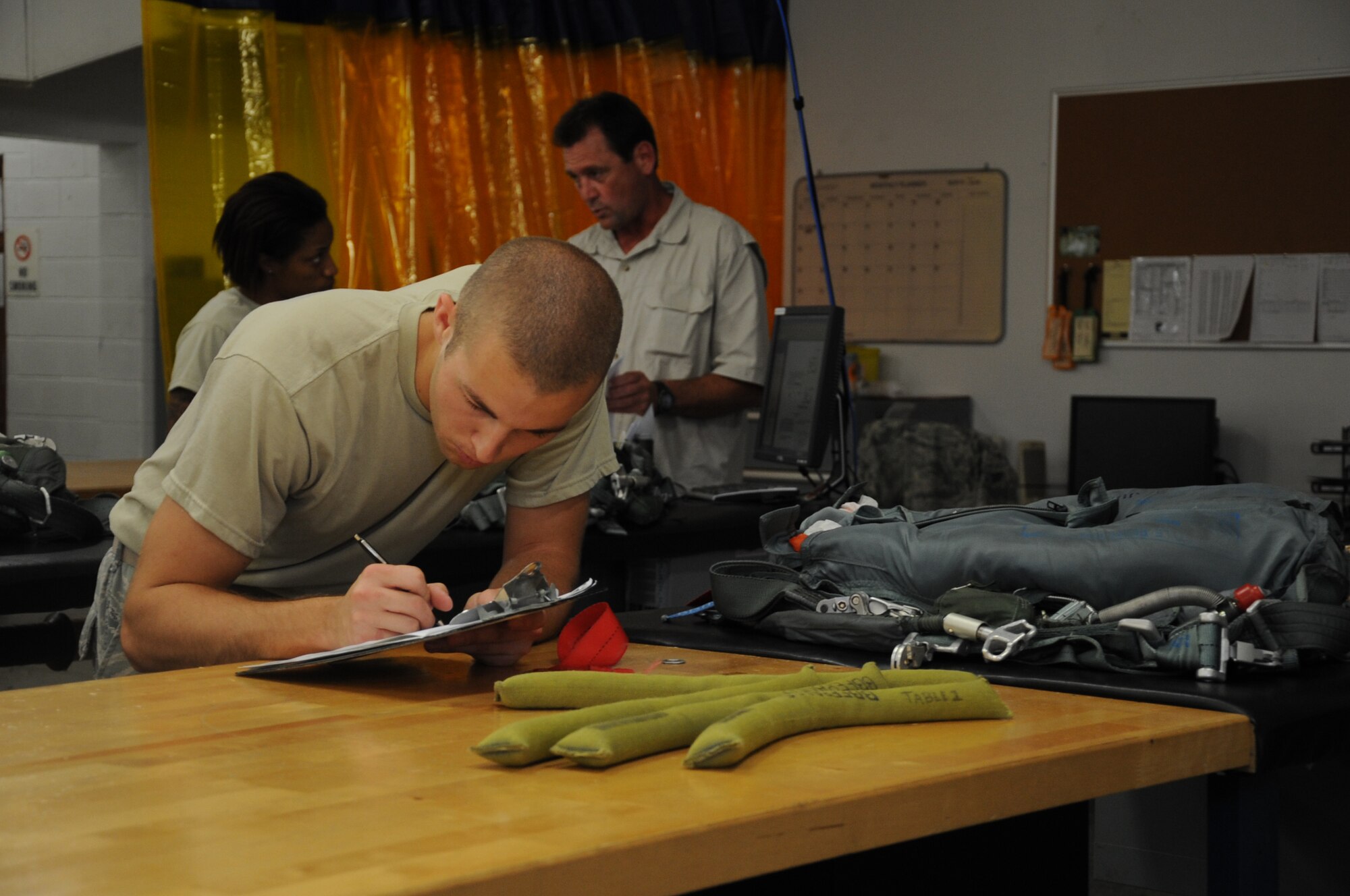 Airman 1st Class Jacob Rush, 2nd Operations Support Squadron aircrew flight equipment parachute shop, completes a checklist for packing parachutes on Barksdale Air Force Base, La., July 2. The checklist must be completed when packing parachutes to ensure the parachute is packed correctly and safely. (U.S. Air Force photo/Senior Airman Sean Martin)(RELEASED)
