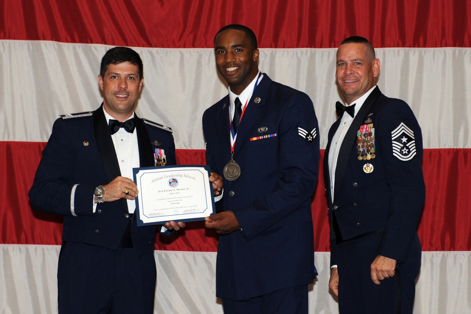 Col. Andrew Gebara, commander of the 2nd Bomb Wing, Senior Airman Ernest J. Sereal, Jr., 307th Civil Engineer Squadron, and Chief Master Sgt. Larry Malcom, command chief for the 2nd Bomb Wing pose for a photo during the graduation ceremonies for Class 12-4 of the Airman Leadership School in Hoban Hall at Barksdale Air Force Base, La., June 28, 2012. The Reserve units at Barksdale receive at least one billet for each month long class. (U.S. Air Force photo by Airman 1st Class Benjamin Gonsier) 