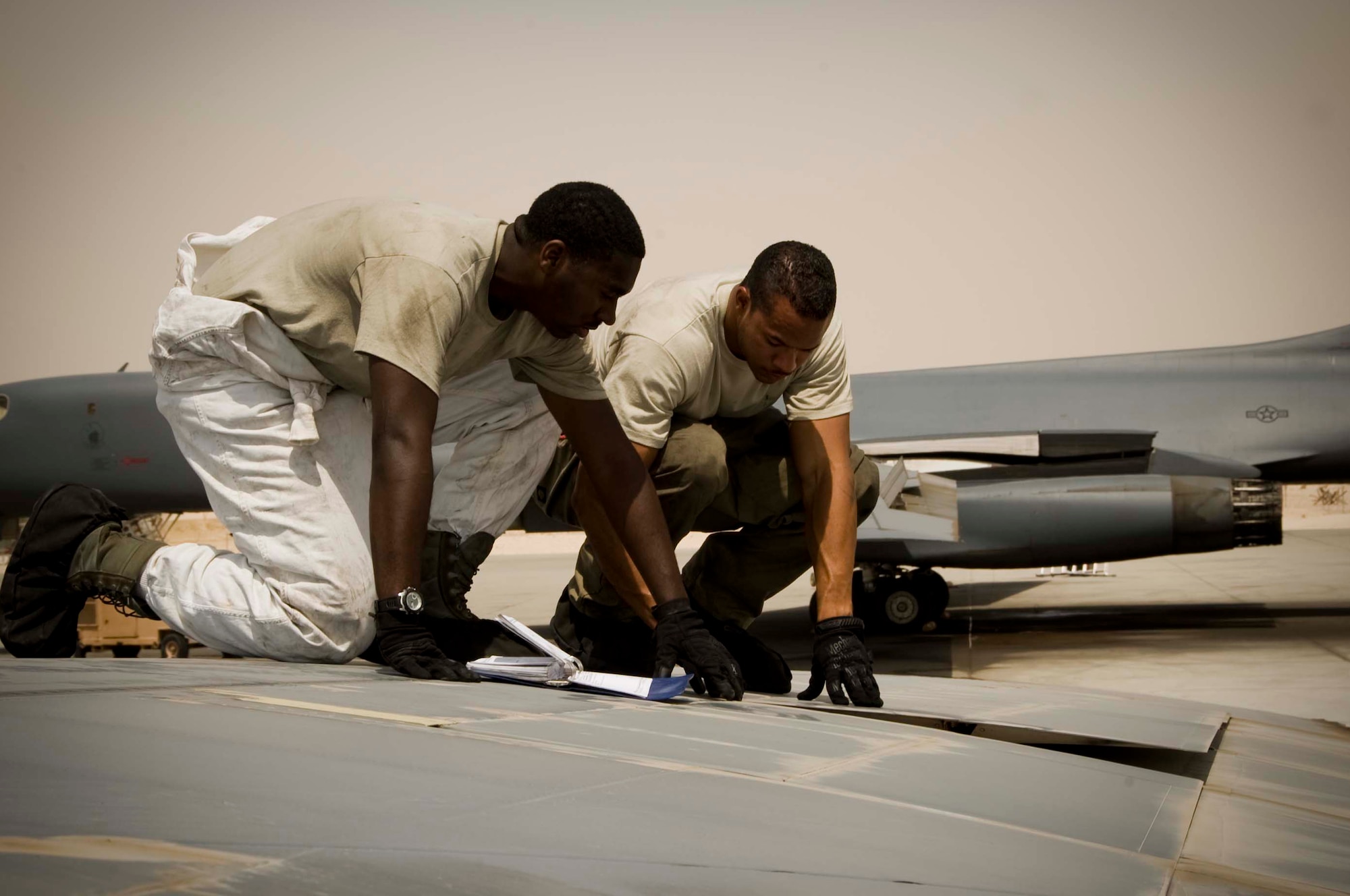 U.S. Air Force Senior Airman Brandon Wharton (foreground), crew chief, and Senior Airman Robert Farris, electrical technician, inspect the spoiler of a B-1 Lancer during a routine post-flight inspection in Southwest Asia, July 2, 2012. Both Airmen are assigned to the 379th Expeditionary Aircraft Maintenance Squadron and are deployed from Dyess Air Force Base, Texas. Wharton is a native of Huntsville, Ala., and Farris is from Killen, Texas. (U.S. Air Force photo/Staff Sgt. Sheila deVera)