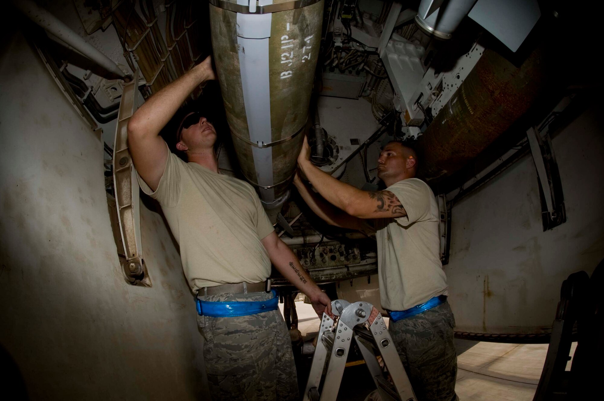 U.S. Air Force Tech. Sgt Shawn Syma (left), weapons load team chief, and Staff Sgt. Duane Gross, weapons technician, inspects mid-arming lube on a GBU-54 during a load process in Southwest Asia, July 2, 2012. Both Airmen are assigned to the 379th Expeditionary Aircraft Maintenance Squadron and are deployed from Dyess Air Force Base, Texas. Syma is a native of Bishop, Texas and Gross is from Tyler, Texas. (U.S. Air Force photo/Staff Sgt. Sheila deVera)