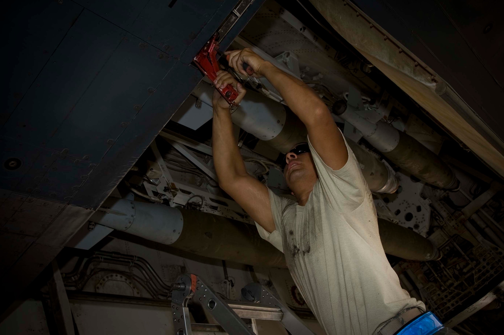 U.S. Air Force Airman 1st Class Julio Lugo, 379th Expeditionary Aircraft Maintenance Squadron weapons load crew member, adjusts the weapons bay handle to safe the munitions in Southwest Asia, July 2, 2012. Lugo is deployed from Dyess Air Force Base, Texas. (U.S. Air Force photo/Staff Sgt. Sheila deVera) 