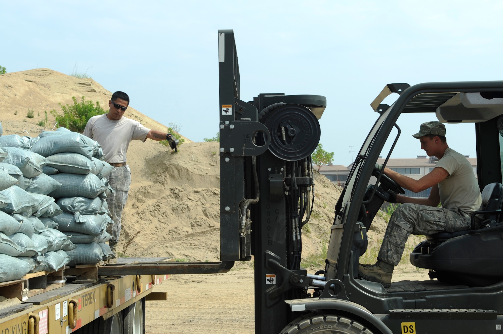 Staff Sgt. Jacob Membreno, left, 8th Civil Engineer Squadron, directs a fellow CES member as he loads sandbags onto a truck June 29, 2012, at Kunsan Air Base, Republic of Korea. Units from the 8th Fighter Wing pitched in to fill sandbags, which will be used throughout the monsoon season. (U.S. Air Force photo/Senior Airman Brigitte N. Brantley)