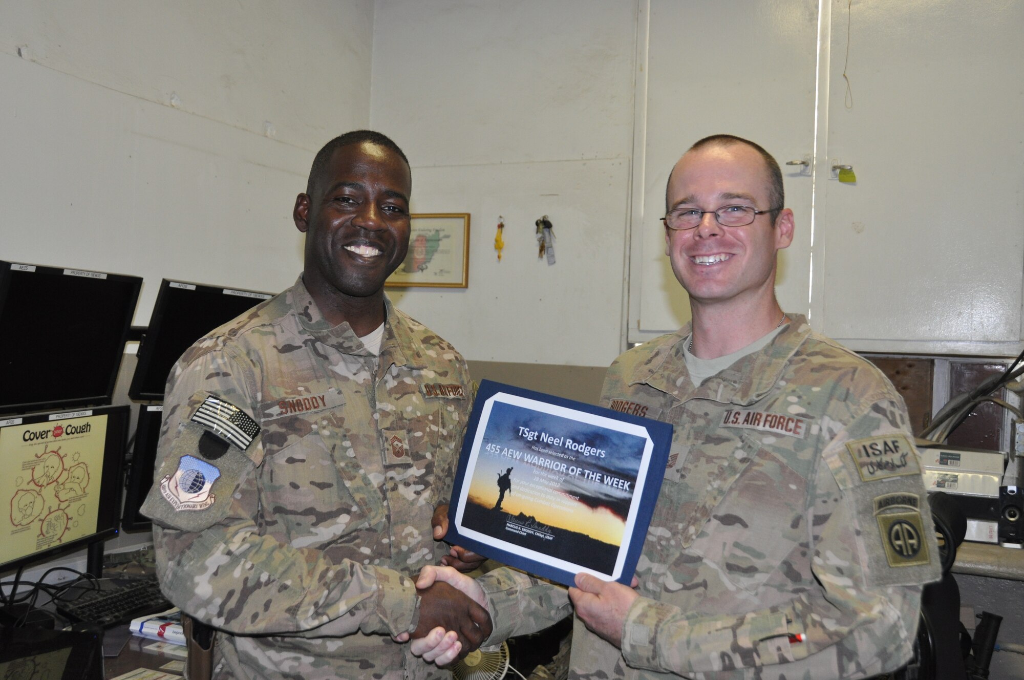 Chief Master Sgt. Marcus Snoddy (left), 455th Air Expeditionary Wing command chief master sergeant, presents the "Warrior of the Week" award to TSgt. Neel Rodgers, a Battlefield Weather Forecaster with 19th Expeditionary Weather Squadron at Bagram Field, Afghanistan. According to Rodgers' peers, his knowledge and accurate anticipation of area weather patterns were instrumental in the successful completion of combat missions leading to interventions against 55 insurgents and the destruction of 82 Improvised Explosive Devices. (U.S. Air Force photo/TSgt Shawn David McCowan)