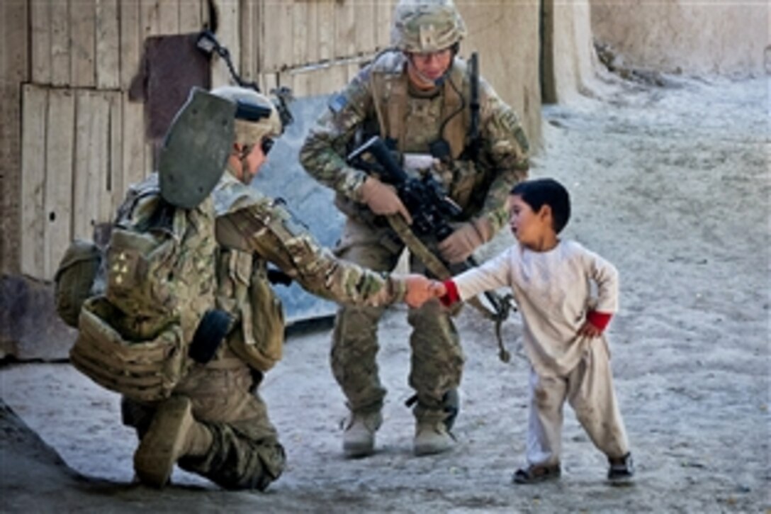 U.S. Army Spc. Harley Young greets an Afghan boy while on patrol in Muqor in Afghanistan's Ghazni province, June 27, 2012. Young is assigned to the 82nd Airborne Division's 1st Battalion, 504th Parachute Infantry Regiment, 1st Brigade Combat Team.