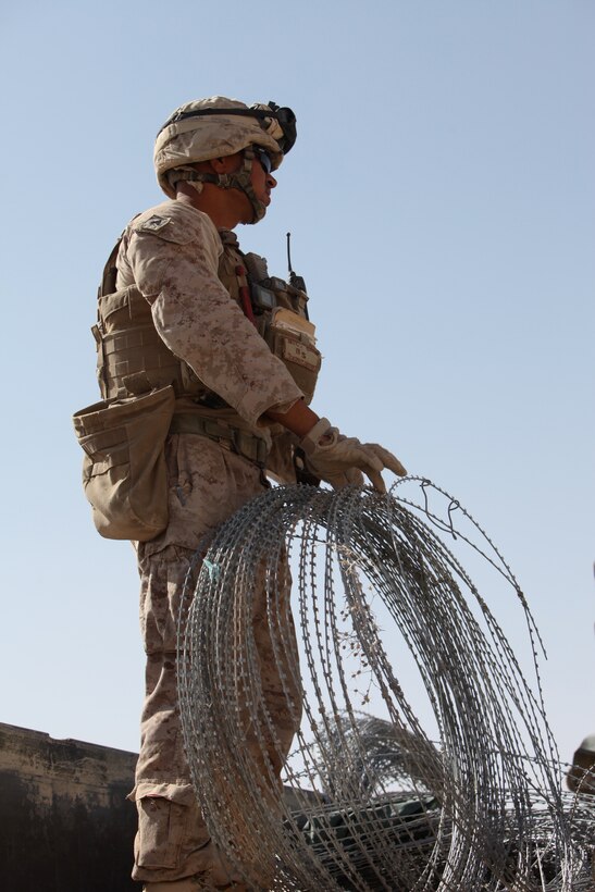 Sgt. Darrell Elisaia, squad leader, Engineer Company, 8th Engineer Support Battalion, 1st Marine Logistics Group (Forward), unloads Concertina-wire during a massive expansion operation at Patrol Base Eredvi, Afghanistan, July 3. “This is the biggest mission I’ve done out of all four deployments,” said Elisaia.