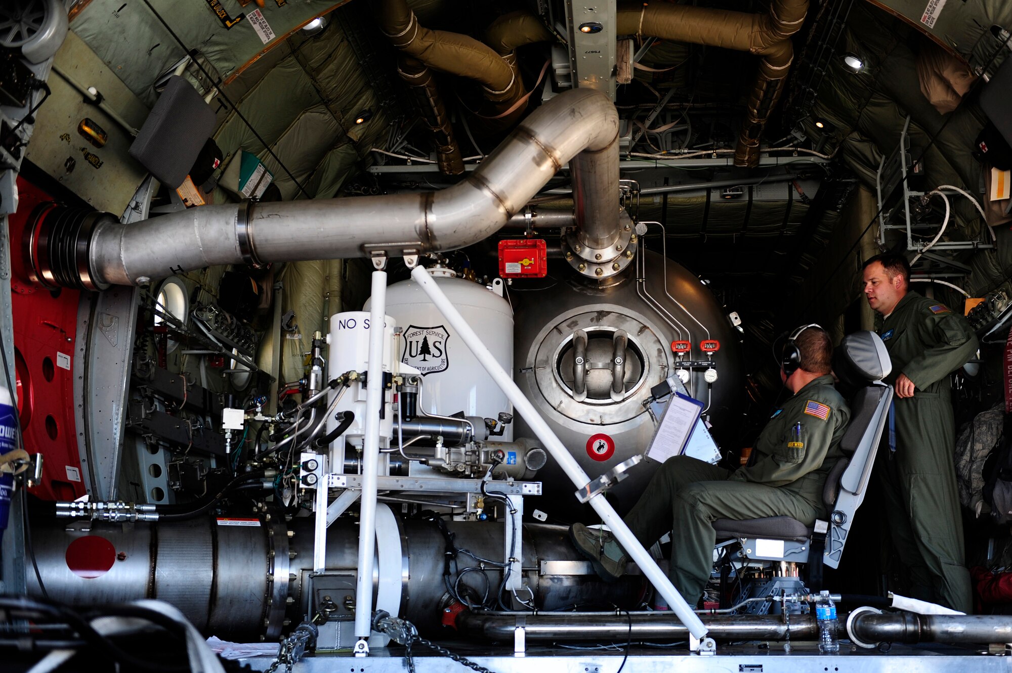 Air National Guard Master Sgts. Marshall Davis and Chris Reese prepare the Modular Airborne Fire Fighting System unit inside their C-130 Hercules aircraft June 27 before launching to respond from Peterson Air Force Base to the Waldo Canyon Fire in Colorado Springs, Colo. MAFFS is a self-contained aerial firefighting system that can discharge 3,000 gallons of water or fire retardant in less than five seconds, covering an area one-quarter of a mile long by 100 feet wide. Davis and Reese are C-130 Hercules loadmasters assigned to the 153rd Airlift Wing, which is based in Cheyenne, Wyo. Peterson AFB is an Air Force installation located in southern Colorado.  (U.S. Air Force photo/Staff Sgt. Stephany D. Richards)