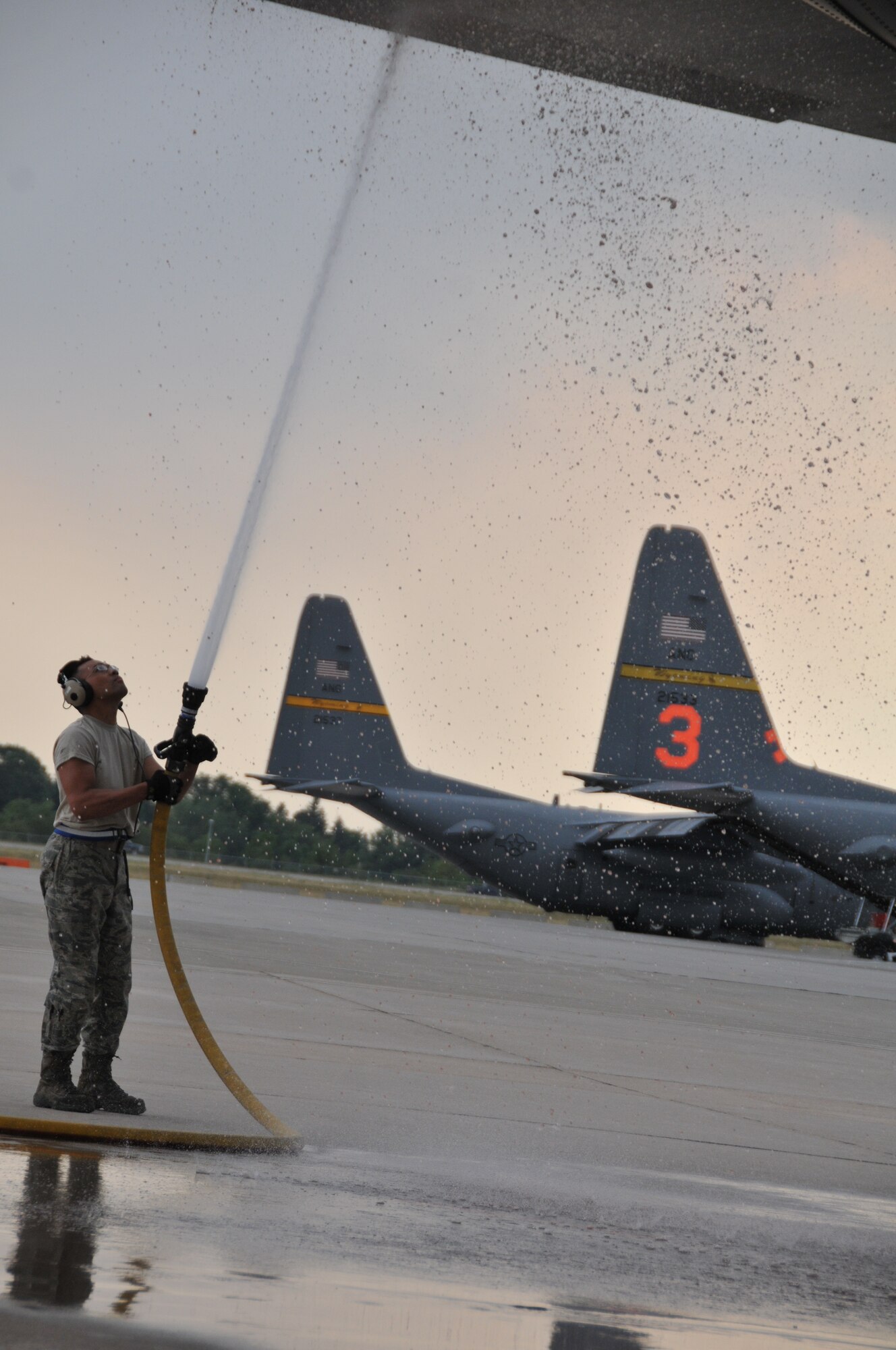 Staff Sgt. Efren Enriquez, 30th Airlift Squadron propulsion craftsman, sprays the tail of a MAFFS-equipped C-130 on the flightline in Cheyenne, Wyo., July 3, 2012. MAFFS aircraft continue to operate in the Rocky Mountain region to assist with firefighting efforts. (U.S. Air Force photo by 1st Lt. Rusty Ridley)