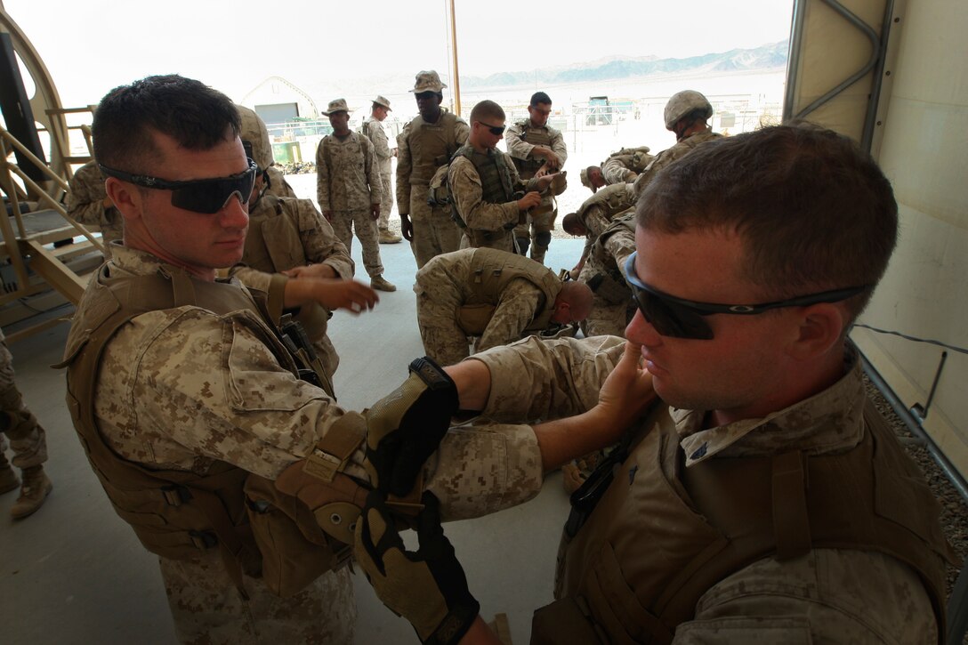 MARINE CORPS AIR GROUND COMBAT CENTER TWENTYNINE PALMS, Calif. - Cpls. Britton Burkett, Danville Va., and Josh Stanley, Richmond Va., with Company C, 4th Combat Engineer Battalion, suit up for Dry Rollover Egress Training aboard Camp Wilson here July 4 during Exercise Javelin Thrust 2012. Javelin Thrust is an annual large-scale exercise which allows active and reserve Marines and Sailors from 38 different states to train together as a seamless Marine Air Ground Task Force. (Photo by Sgt. Alvin D. Parson/Released)