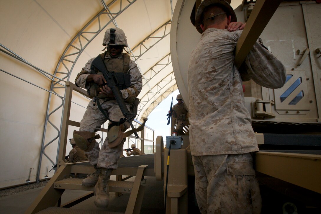 MARINE CORPS AIR GROUND COMBAT CENTER TWENTYNINE PALMS, Calif. - Cpl. Justin Wilson, Lynchburg Va., with Company C, 4th Combat Engineer Battalion, rushes from a Mine Resistant Ambush Protected Vehicle Egress Trainer aboard Camp Wilson here July 4 during Exercise Javelin Thrust 2012. Javelin Thrust is an annual large-scale exercise which allows active and reserve Marines and Sailors from 38 different states to train together as a seamless Marine Air Ground Task Force. (Photo by Sgt. Alvin D. Parson/Released)