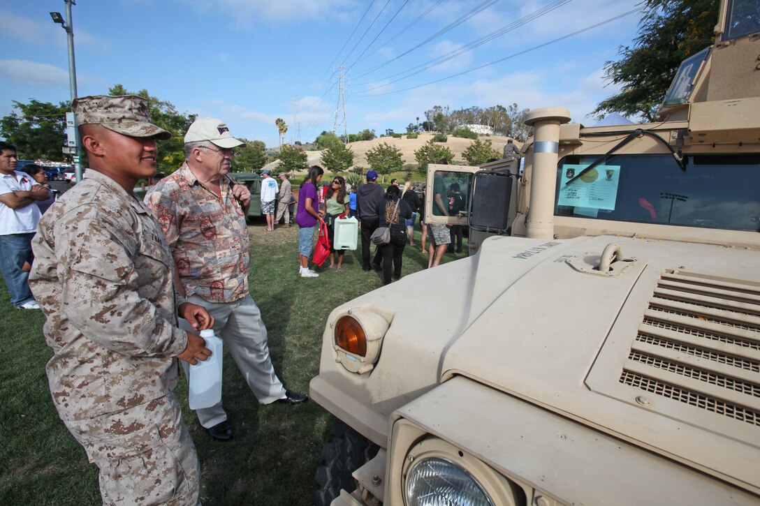 Lance Cpl. Meng Thao, machine gunner, Company K, Battalion Landing Team 3/5, 15th Marine Expeditionary Unit, speaks with a visitor at a static display in Laguna Hills, Calif., July 4. With help from Laguna Hills Team Darkhorse, a charitable organization that supports  BLT 3/5, the Marines and sailors displayed a Humvee, Landing Assault Vehicle, Landing Strike Vehicle, equipment and weapons before a fireworks display kicked off that evening. Thao, 20, is from Sacramento, Calif.