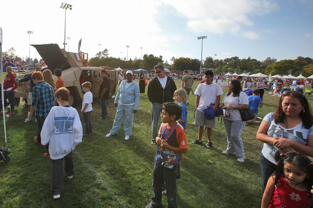 Families from the local community visit a Marine Corps static display from Battalion Landing Team 3/5, 15th Marine Expeditionary Unit, during an Independence Day celebration at Laguna Hills, Calif., July 4. With help from Laguna Hills Team Darkhorse, a charitable organization that supports BLT 3/5, the Marines and sailors displayed a Humvee, Landing Assault Vehicle, Landing Strike Vehicle, equipment and weapons before a fireworks display kicked off that evening. The servicemembers spent the 4th of July educating and interacting with the Laguna Hills community to develop a deeper understanding of what the Marines and sailors do.