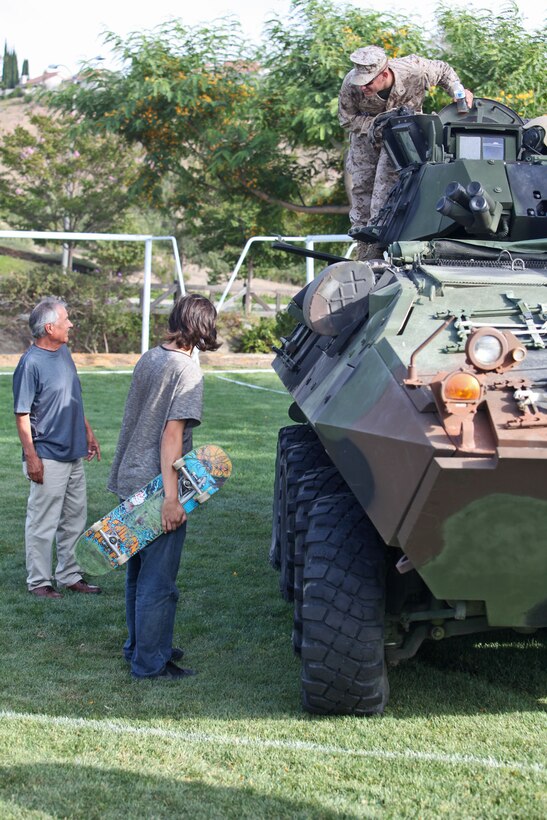 1st Lieutenant Joshua J. Abraham, infantry officer, 1st Light Armored Reconnaissance Battalion,  Battalion Landing Team 3/5, 15th Marine Expeditionary Unit, answers questions from visitors at a static display in Laguna Hills, Calif., July 4. With help from Laguna Hills Team Darkhorse, a charitable organization that supports BLT 3/5, the Marines and sailors displayed a Humvee, Landing Assault Vehicle, Landing Strike Vehicle, equipment and weapons before a fireworks display kicked off that evening. The servicemembers spent Independence Day educating and interacting with the Laguna Hills community to develop a deeper understanding of what the Marines and sailors do.