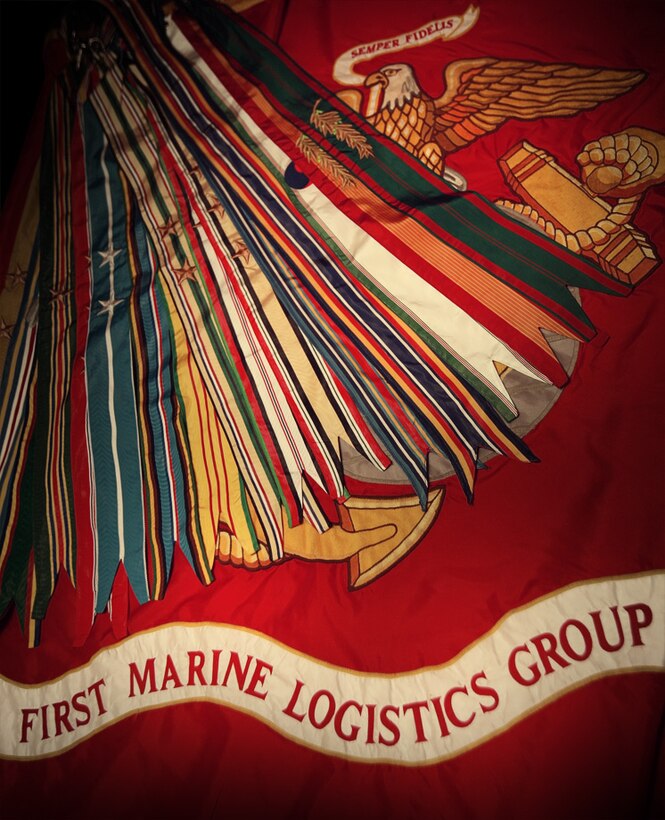 The 1st Marine Logistics Group battle colors proudly displays the various campaign and battle streamers the 1st MLG has been awarded during its 65 year history. Marines and sailors with 1st Marine Logistics Group (Forward) celebrated the 65th Anniversary of the logistics group during a morning colors ceremony on Camp Leatherneck, Afghanistan, July 2.