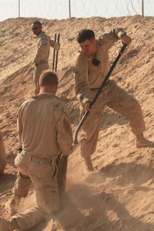 Sergeant Bryan Ross, (right) squad leader, Bravo Company, Light Armored Reconnaissance Platoon, 1st Combat Engineer Battalion, helps his Marines fill sandbags during Operation Stronghold, June 29. Ross, a Fairfield, Calif., native has his sights set on becoming a career Marine and hopes to one day become a master gunnery sergeant.