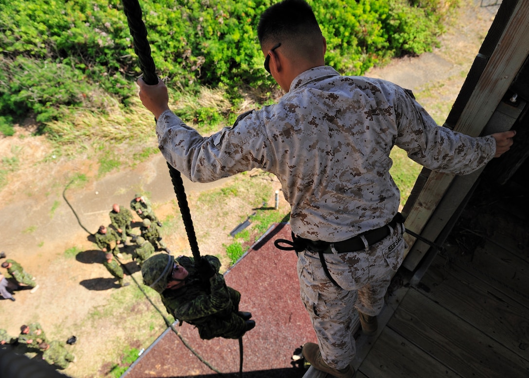 Corporal Jerel Bersolona (right), Rappel Master from 1st Battalion, 3rd Marine Regiment, helps members from 2nd Battalion Princess Patricia's Canadian Light Infantry from Shilo, Manitoba, practice the Fast Rope Insertion Extraction System, at Marine Corps Base Hawaii, July 2. Twenty-two nations, more than 40 ships and submarines, and more than 200 aircraft and 25,000 personnel are participating in the biennial Rim of the Pacific (RIMPAC) exercise from June 29 to Aug. 3, in and around the Hawaiian Islands. The world's largest international maritime exercise, RIMPAC provides a unique training opportunity that helps participants foster and sustain the cooperative relationships that are critical to ensuring the safety of sea lanes and security on the world's oceans. RIMPAC 2012 is the 23rd exercise in the series that began in 1971.