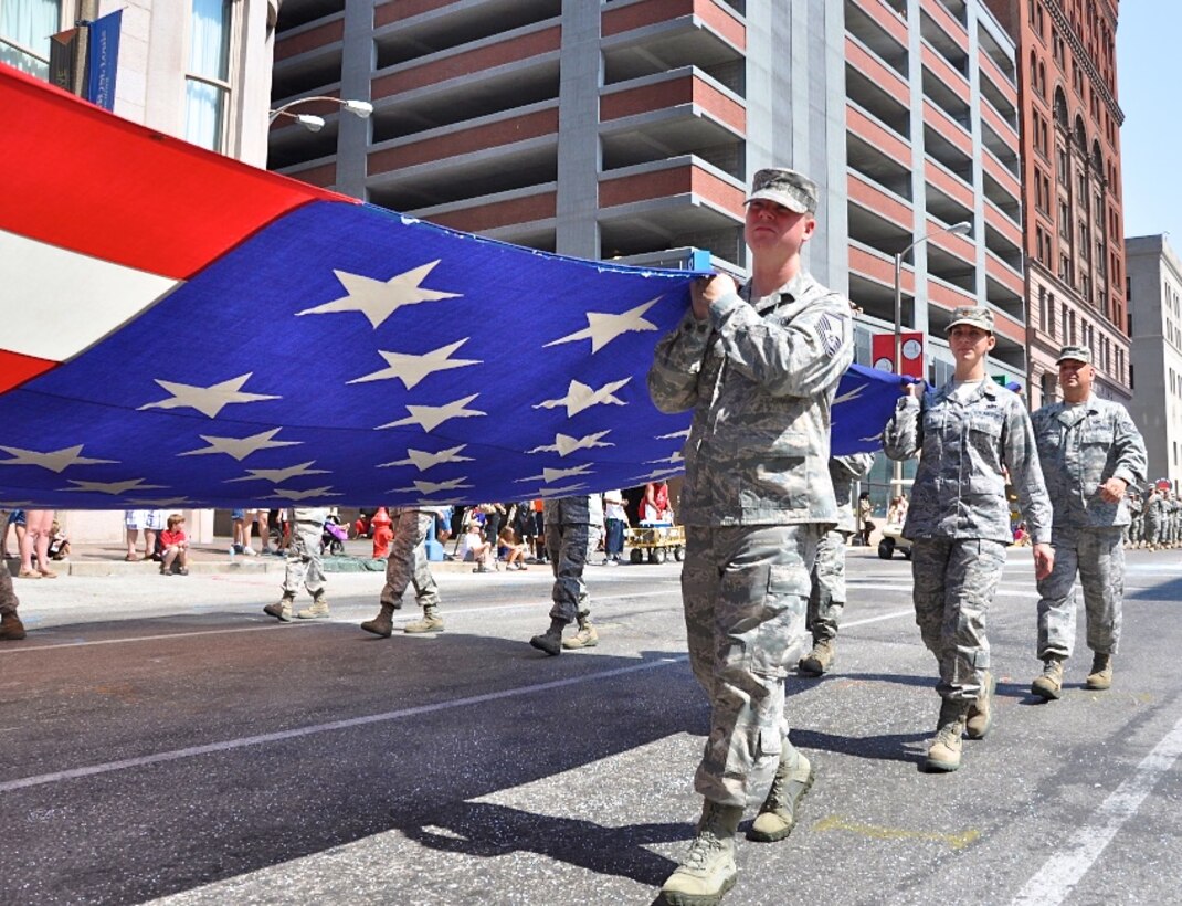 Some 25 reservists from the 932nd Airlift Wing march the U.S. flag in the 135th annual Veiled Prophet  Fair Parade in downtown St. Louis.   The reservists and thousand of cheering specators ignored the 103 degree heat and enjoyed one of the largest Independence Day parades held in the U.S.   The 932nd AW, is known as the Gateway Wing, for its close proximity to the Gateway Arch.   The reserve wing  is located at Scott Air Force Base, Ill., and flies the C-40C airplane.  (U.S. Air Force photo/Tech. Sgt. Dan Oliver)  
