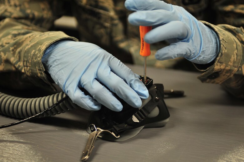 U.S. Air Force Senior Airman Nicholas Byars, 27th Special Operations Support Squadron aircrew flight equipment specialist, tightens screws on an oxygen mask at Cannon Air Force Base, N.M., July 3, 2012. Aircrew flight equipment specialists inspect, maintain and adjust life support and survival gear for flight crew members assigned to Cannon. (U.S. Air Force photo by Airman 1st Class Eboni Reece)