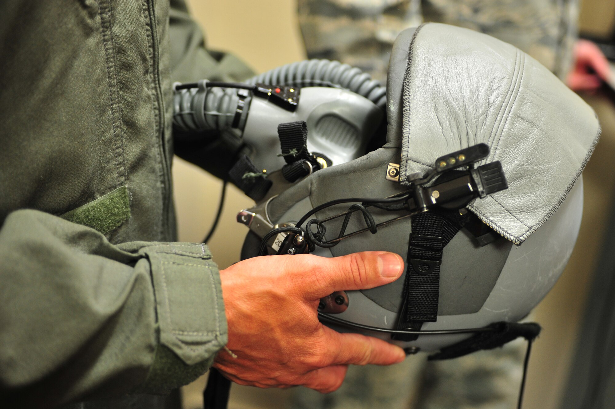U.S. Air Force Capt. Jeremy Sparks, 16th Special Operations Squadron pilot, holds his helmet and oxygen mask after it was checked for leaks at Cannon Air Force Base, N.M., July 3, 2012. Aircrew flight equipment specialists inspect, maintain and adjust life support and survival gear for flight crew members assigned to Cannon. (U.S. Air Force photo by Airman 1st Class Eboni Reece)
