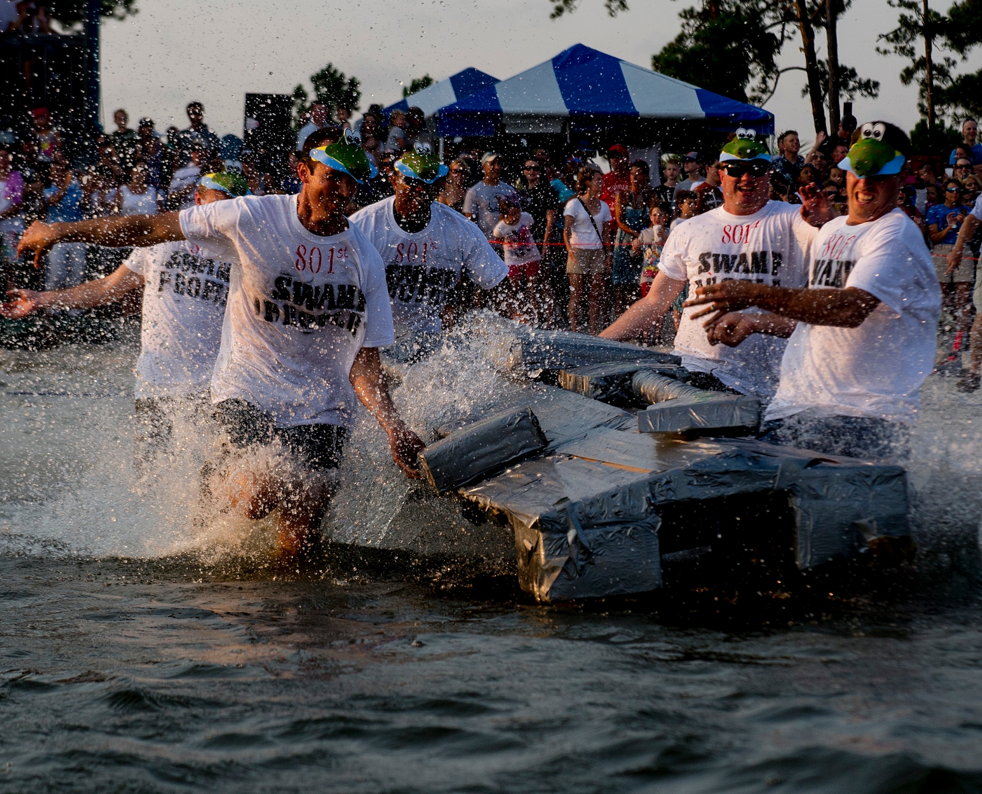 U.S. Air Force airmen from the 801st Special Operations Aircraft Maintenance Squadron run into the water during the 24th Annual Cardboard Boat Regatta at the marina on Hurlburt Field, Fla., June 29, 2012. Fifteen squadrons created boats out of cardboard, duct tape and paint. (U.S. Air Force photo / Airman 1st Class Christopher Williams) (RELEASED)
