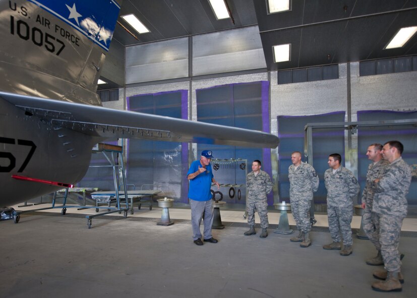 Airmen of all ranks stop and listen to U.S. Air Force retired Master Sgt. Carl Hackworth as he tells stories about the F-86L Sabre when he worked on it as a young crew chief in the 1950s at the fabrication flight June 11, 2012, at Moody Air Force Base, Ga. Hackworth got a first-hand look at the refurbishment progress on the aircraft and was pleased with the results. (U.S. Air Force photo by Senior Airman Eileen Meier/Released)