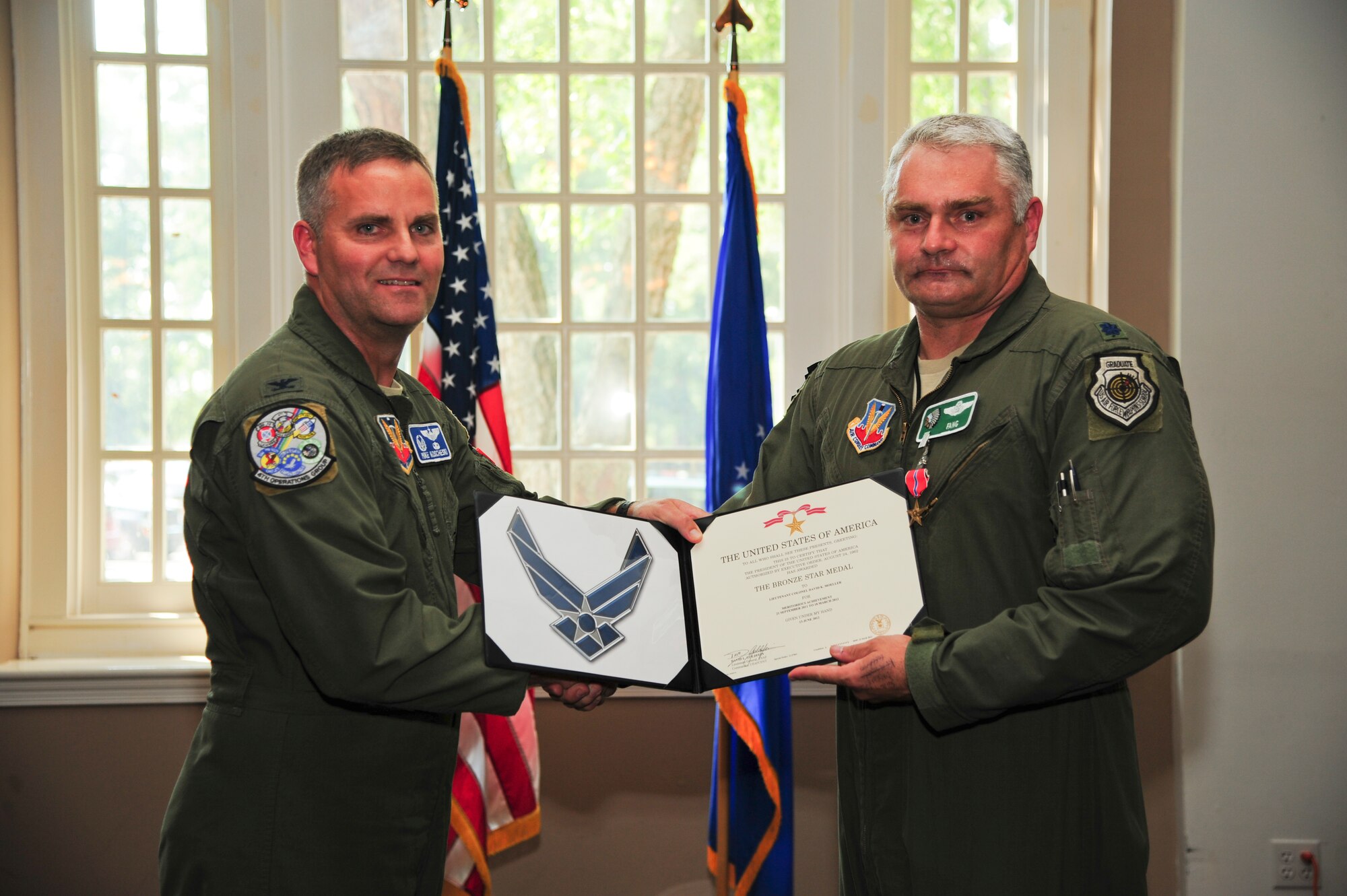 U.S. Air Force Col. Michael Koscheski, 4th Operations Group commander, presents Lt. Col. David Moeller, 335th Fighter Squadron commander, with a Bronze Star Medal on Seymour Johnson Air Force Base, N.C., June 29, 2012. Moeller was presented the medal for his leadership in projecting lethal airpower in support of Operation ENDURING FREEDOM. (U.S. Air Force photo/Tech. Sgt. Colette Graham/Released)