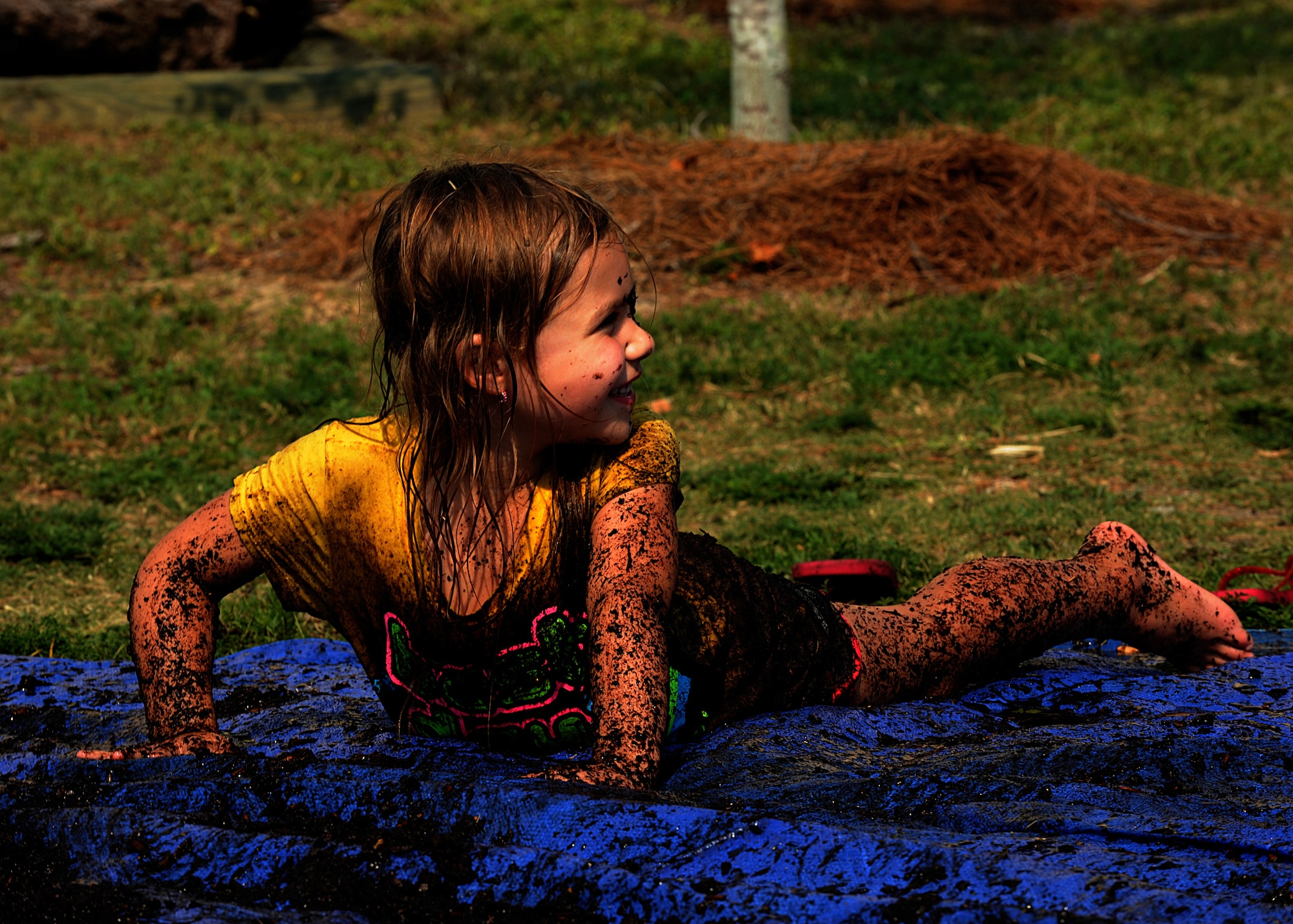 Valerie Martin, 5, daughter of U.S. Army Staff Sgt. Kyle Martin, a ranger instructor with 6 Ranger Training Battalion at Camp Rudder, Fla., plays in dirt during a Mud Day event at the library in Hurlburt Field, Fla., June. 30, 2012. International Mud Day was initiated to educate children on nature. (U.S Air Force Photo/Airman 1st Class Nigel Sandridge/Released)