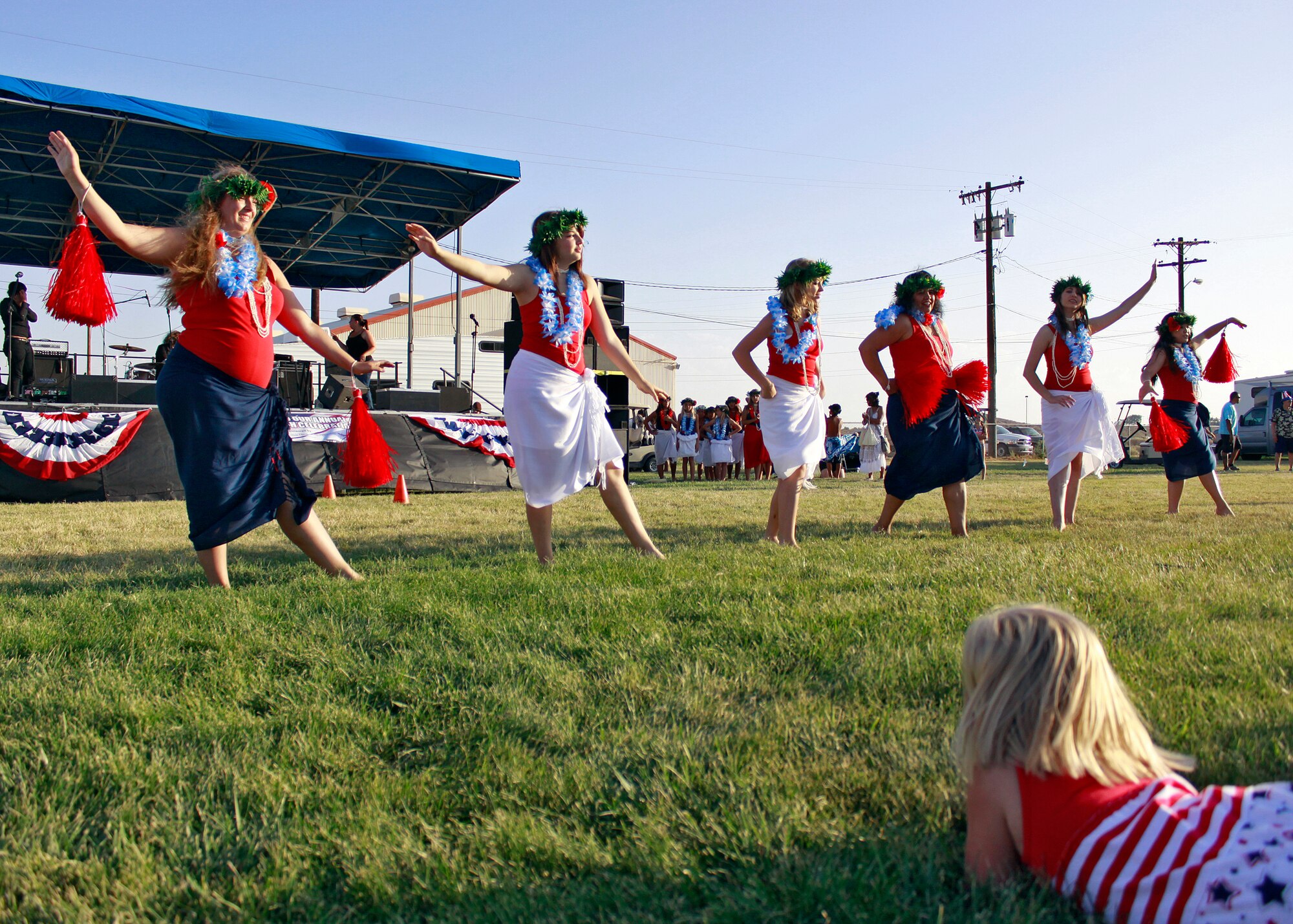 A little girl looks on as members from the Ka Ohana O Keolanani’s Hula Halau dance troupe provide entertainment on Wings Field prior to July 4th’s fireworks extravaganza at Edwards Air Force Base, Calif. This year's Summer Bash festivities kicked off at 4:30 p.m. (U.S. Air Force photo by Jet Fabara)