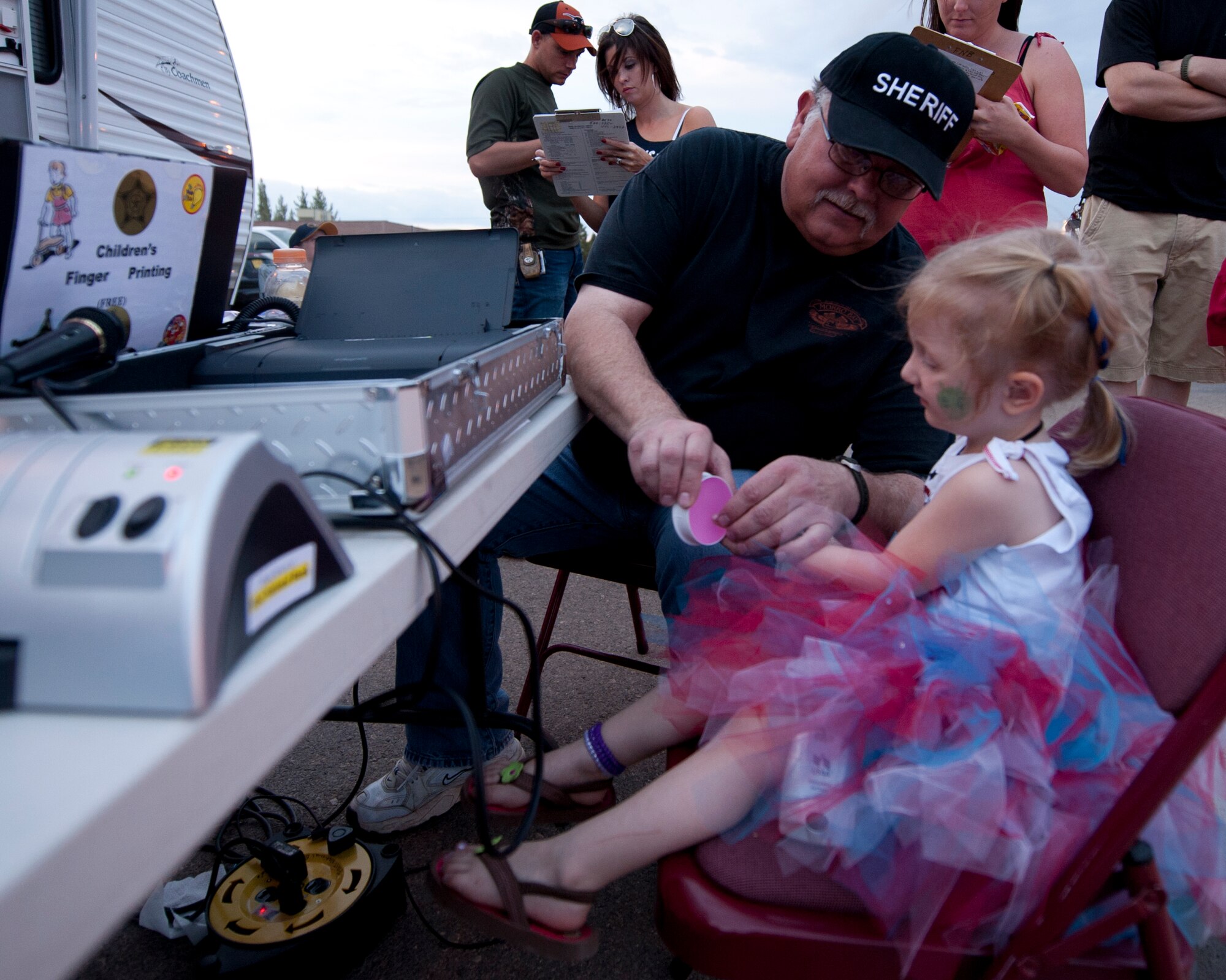 A child gets her fingerprints scanned during the Freedom Fest Independence Day celebration at Holloman Air Force Base N.M., July 3. Members of local law enforcement agencies scanned children’s fingerprints as part of a county-wide program to keep children safe. The Freedom Fest, which took place in the Domenici Fitness and Sports Center parking lot, also included carnival games, rides, live music, and a fireworks display for Airmen and their families. (U.S. Air Force photo by Airman Leah Ferrante/Released)