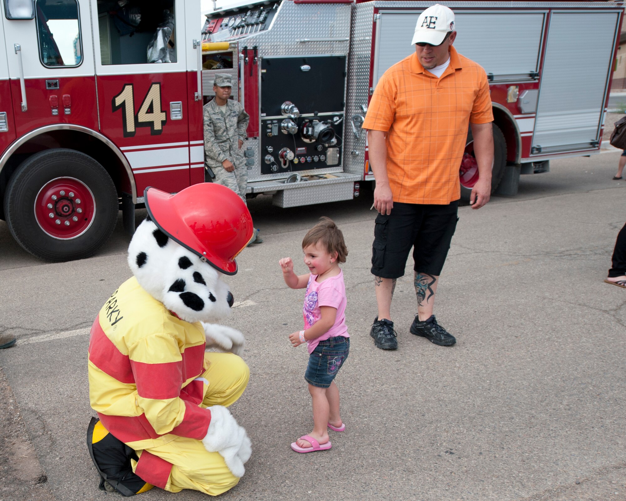 A child interacts with Sparky the Fire Dog during the Freedom Fest Independence Day celebration at Holloman Air Force Base N.M., July 3. Sparky and 49th Civil Engineer Squadron firefighters were at the celebration to give tours of the fire trucks, show off their fire-fighting equipment, and raise fire-safety awareness. The Freedom Fest, which took place in the Domenici Fitness and Sports Center parking lot, also included carnival games, rides, live music, and a fireworks display for Airmen and their families. (U.S. Air Force photo by Airman Leah Ferrante/Released)
