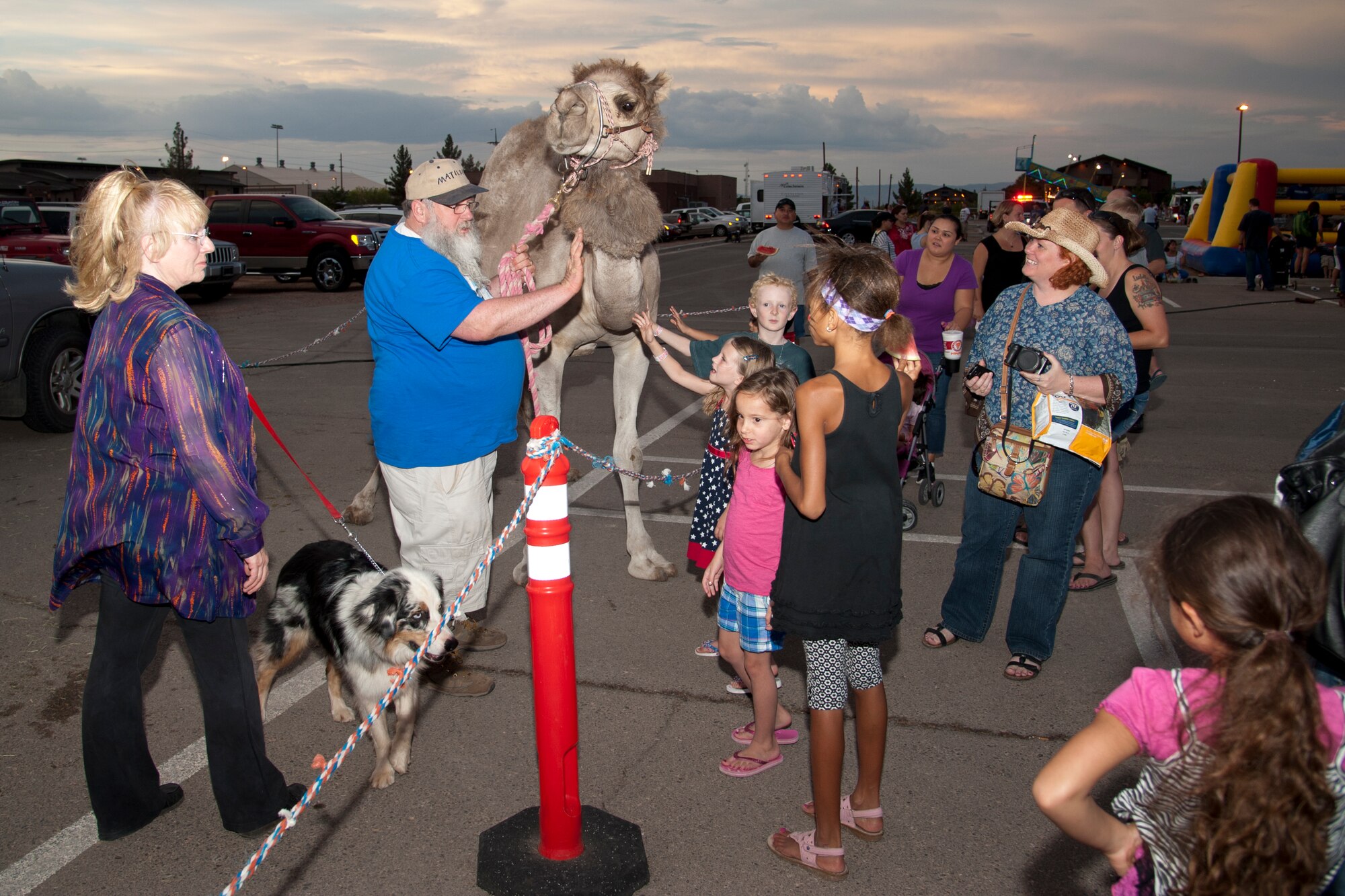 Members of Team Holloman interact with Matilda the camel during the Freedom Fest Independence Day celebration at Holloman Air Force Base, N.M., July 3. Freedom Fest took place in the Domenici Fitness and Sports Center parking lot and included carnival games, rides, live music, and a fireworks display for Airmen and their families. (U.S. Air Force photo by Airman 1st Class Anthony M. Ward/Released)