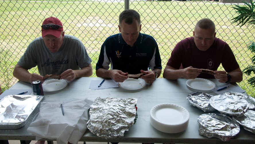 U.S. Air Force Col. Billy Thompson, 23d Wing commander, center, Col. Steven Ramer, 23d WG vice commander, left, and Chief Master Sergeant Michael Goetz, 93d Air Ground Operations Wing command chief, serve as judges during an Independence Day celebration cook off at Moody Air Force Base, Ga. Thompson, Ramer and Goetz judged ribs and burgers to determine which were the best. (U.S. Air Force photo by Airman 1st Class Paul Francis/Released) 