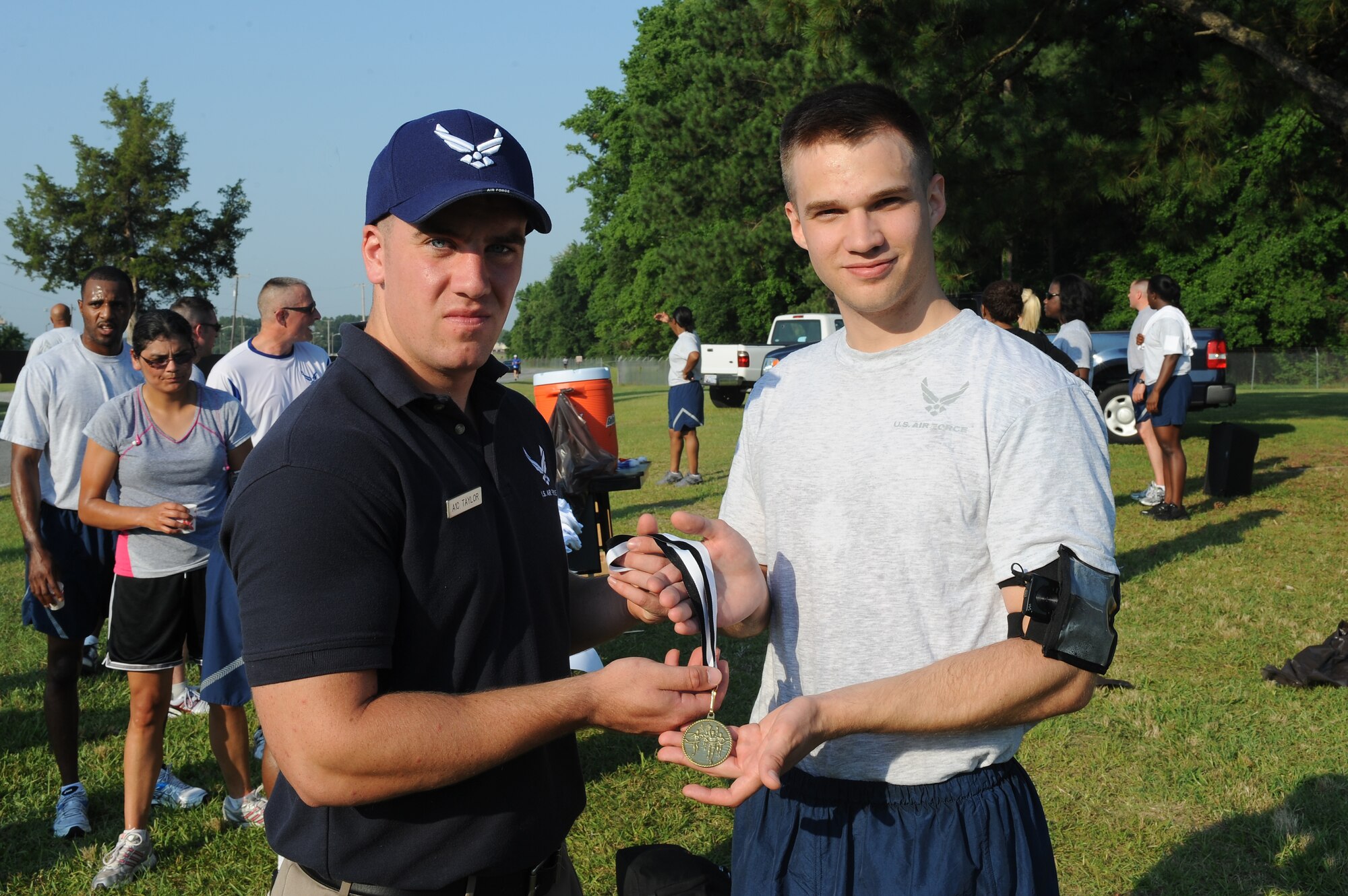 U.S. Air Force Airman 1st Class Jeffery Taylor presents a medal to Airman 1st Class Matthew Cotter after he finished the Freedom Run on Seymour Johnson Air Force Base, N.C., June 29, 2012. Cotter finished first in the 5k run with a time of 19:25. Taylor, 4th Force Support Squadron fitness apprentice, hails from Helena, Mont. Cotter, 4th FSS customer support apprentice, is a native of L’Anse, Mich. (U.S. Air Force photo/Airman 1st Class John Nieves Camacho/Released)