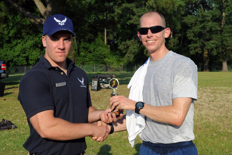 U.S. Air Force Airman 1st Class Jeffery Taylor presents a trophy to 1st Lt. Grant Bloom after he finished the Freedom Run on Seymour Johnson Air Force Base, N.C., June 29, 2012. Bloom finished first in the 10k run with a time of 42:11. Taylor, 4th Force Support Squadron fitness apprentice, is a native of Helena, Mont. Bloom, 4th Civil Engineer Squadron section commander, is from Colorado Springs, Colo. (U.S. Air Force photo/Airman 1st Class John Nieves Camacho/Released)