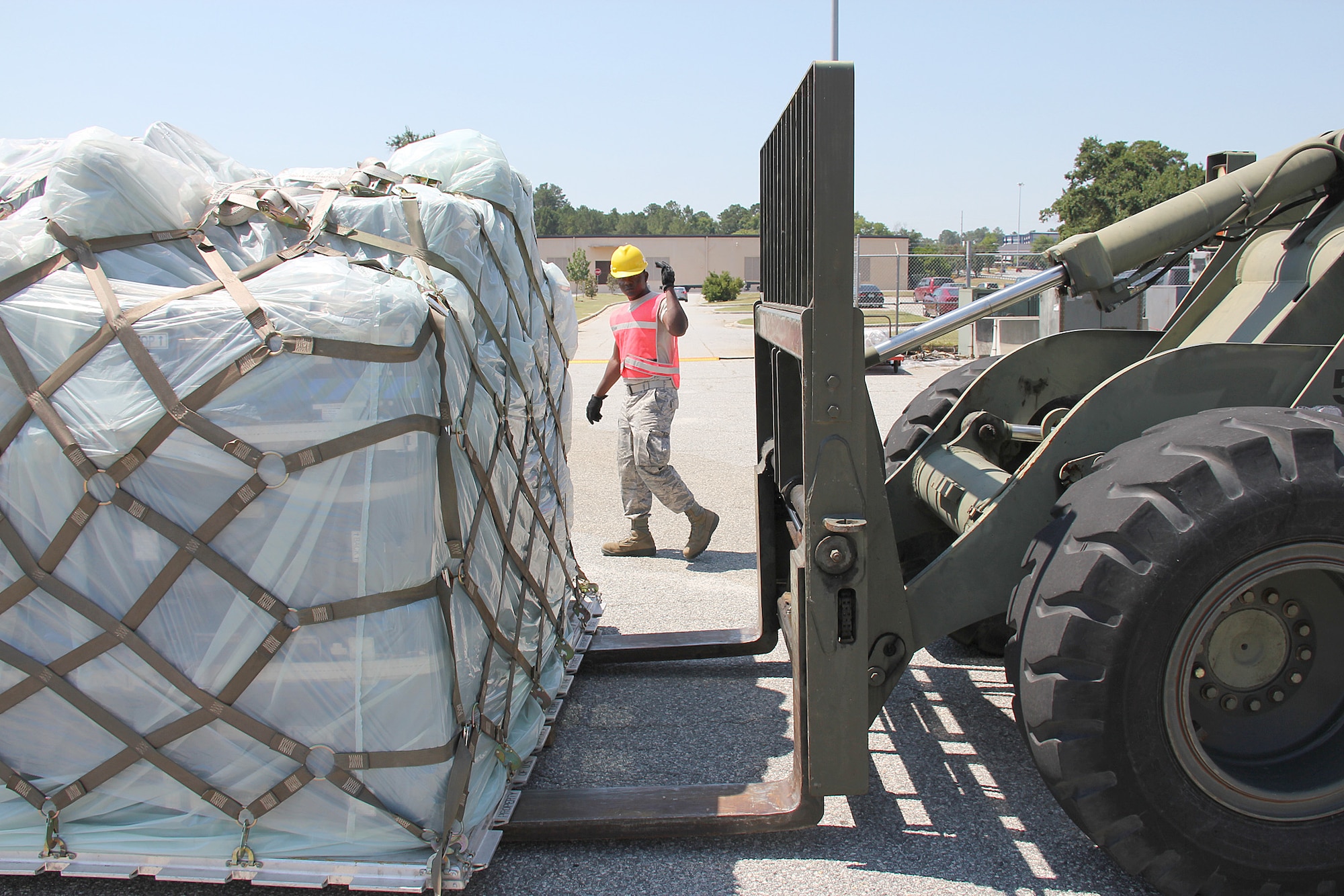 Senior Airman Madjassah Moussa, 51st Combat Communications Squadron heating, ventilation and air conditioning technician, marshals the movement of a pallet to a flatbed truck.(U. S. Air Force photo/ Robert Talenti)