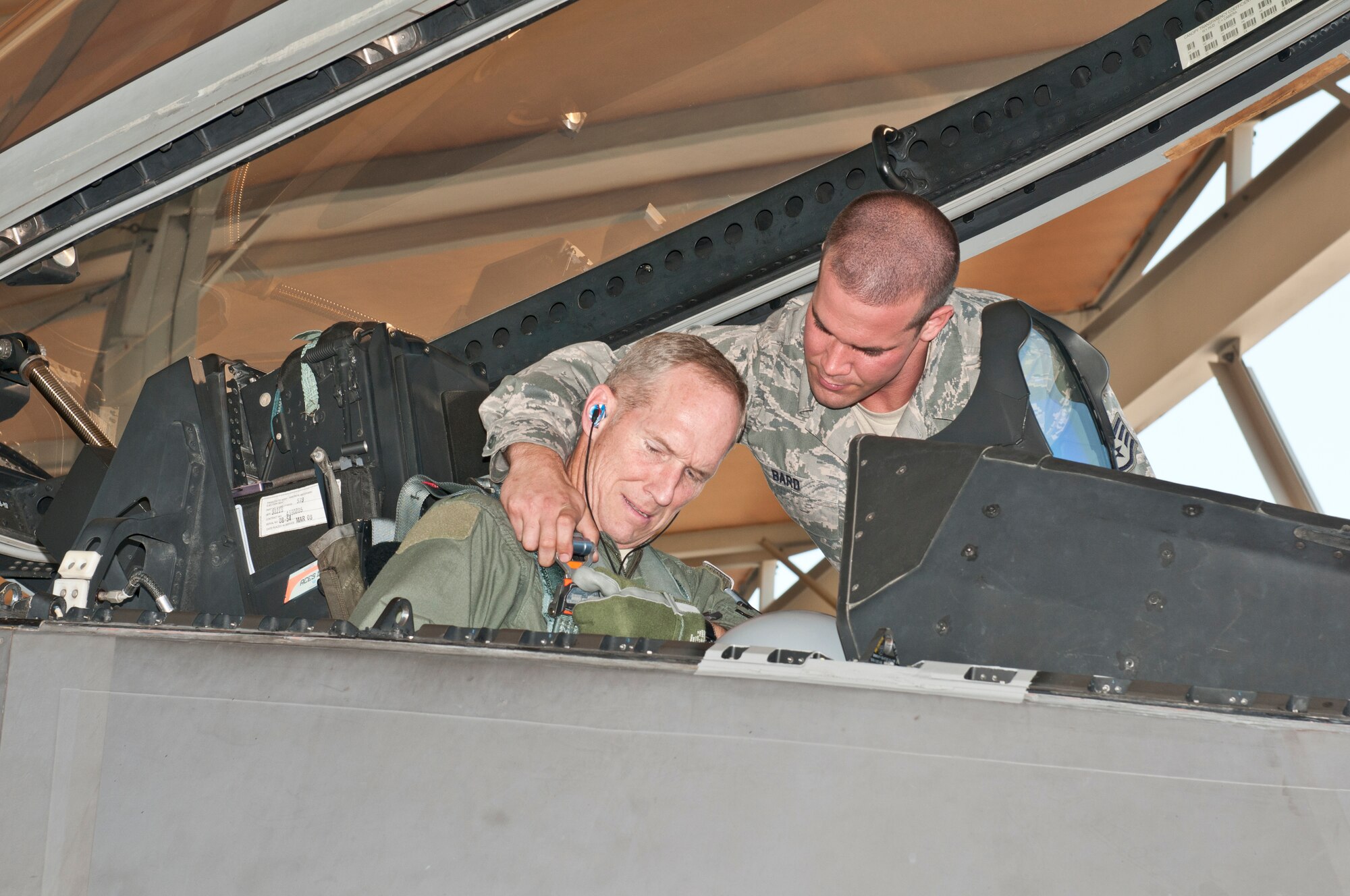 Staff Sgt. Joshua Bard straps Gen. Mike Hostage into an F-22 Raptor for his qualification flight at Tyndall Air Force Base, Fla., June 27, 2012. Hostage is the commander of Air Combat Command and Bard is a crew chief with the 43rd Aircraft Maintenance Unit. (U.S. Air Force photo/Christopher Cokeing)
