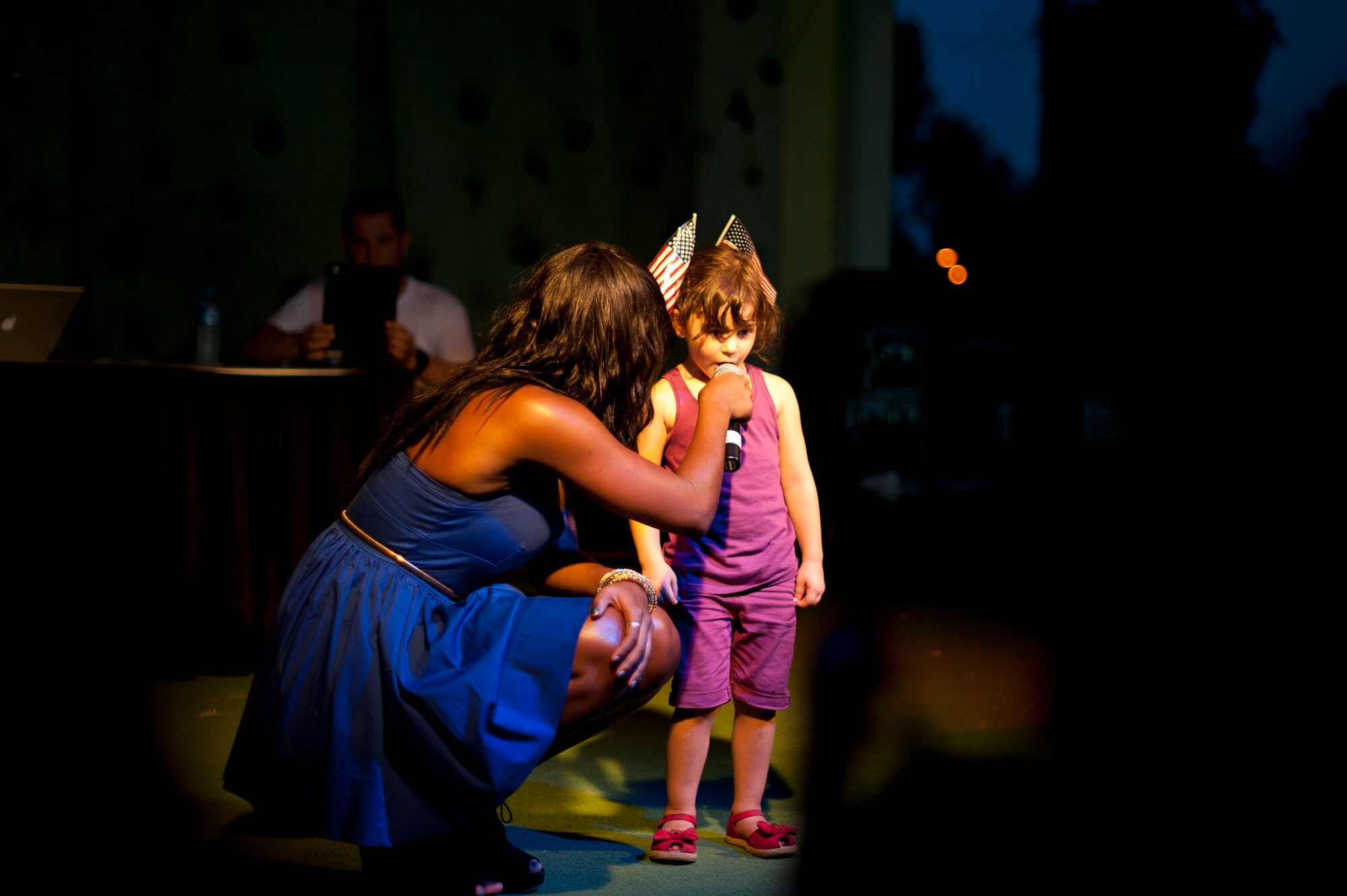 American Idol contestant Ta-Tynisa Wilson holds a microphone for a member of the audience to sing during a performance at Incirlik Air Base, Turkey's Independence Day celebration July 4, 2012, at Arkadas Park. Team Incirlik celebrated Independence Day with various activities, food and live entertainment. (U.S. Air Force photo by Senior Airman William A. O'Brien/released)